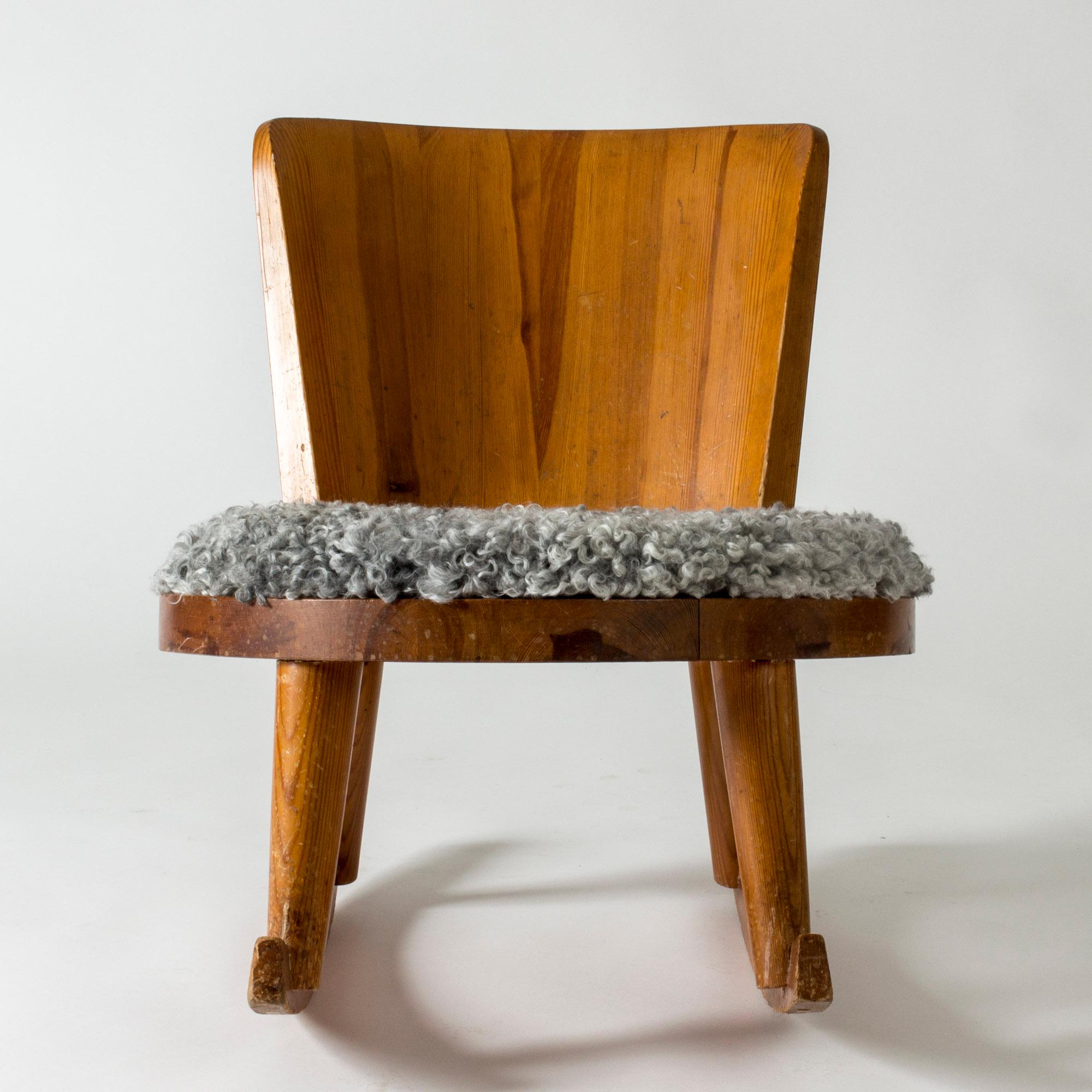 Cool modernist rocking chair by Torsten Claesson, made from pine with a removable sheepskin cushion. Neat design with rounded lines.