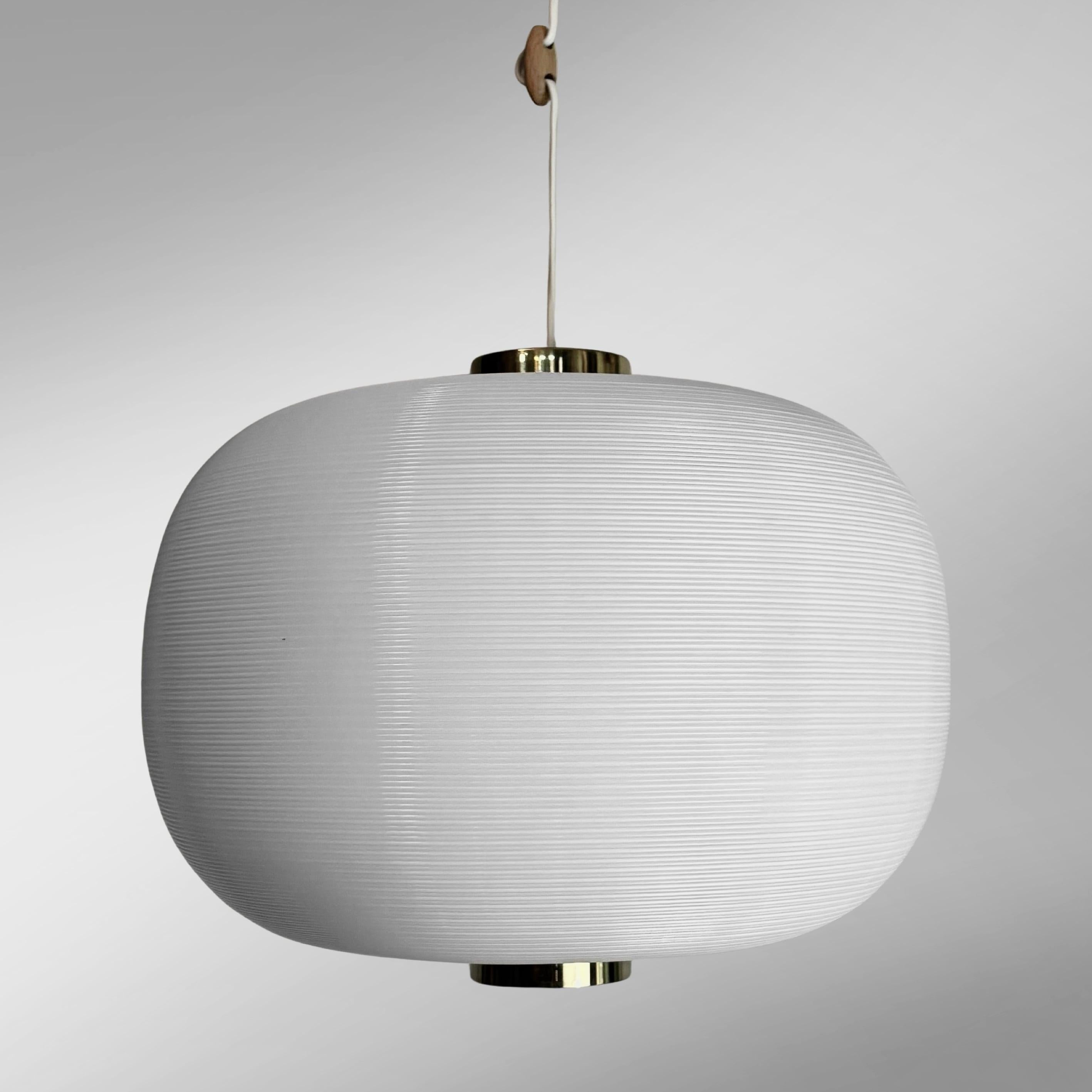 A Scandinavian modernist pendant lamp, model TR-67, designed by Alf Svensson and Yngvar Sandström for the Swedish manufacturer Bergbom & Co in the 1960s. It features a softly shaped shade made of Rotoflex plastic with cylindrical brass details. The