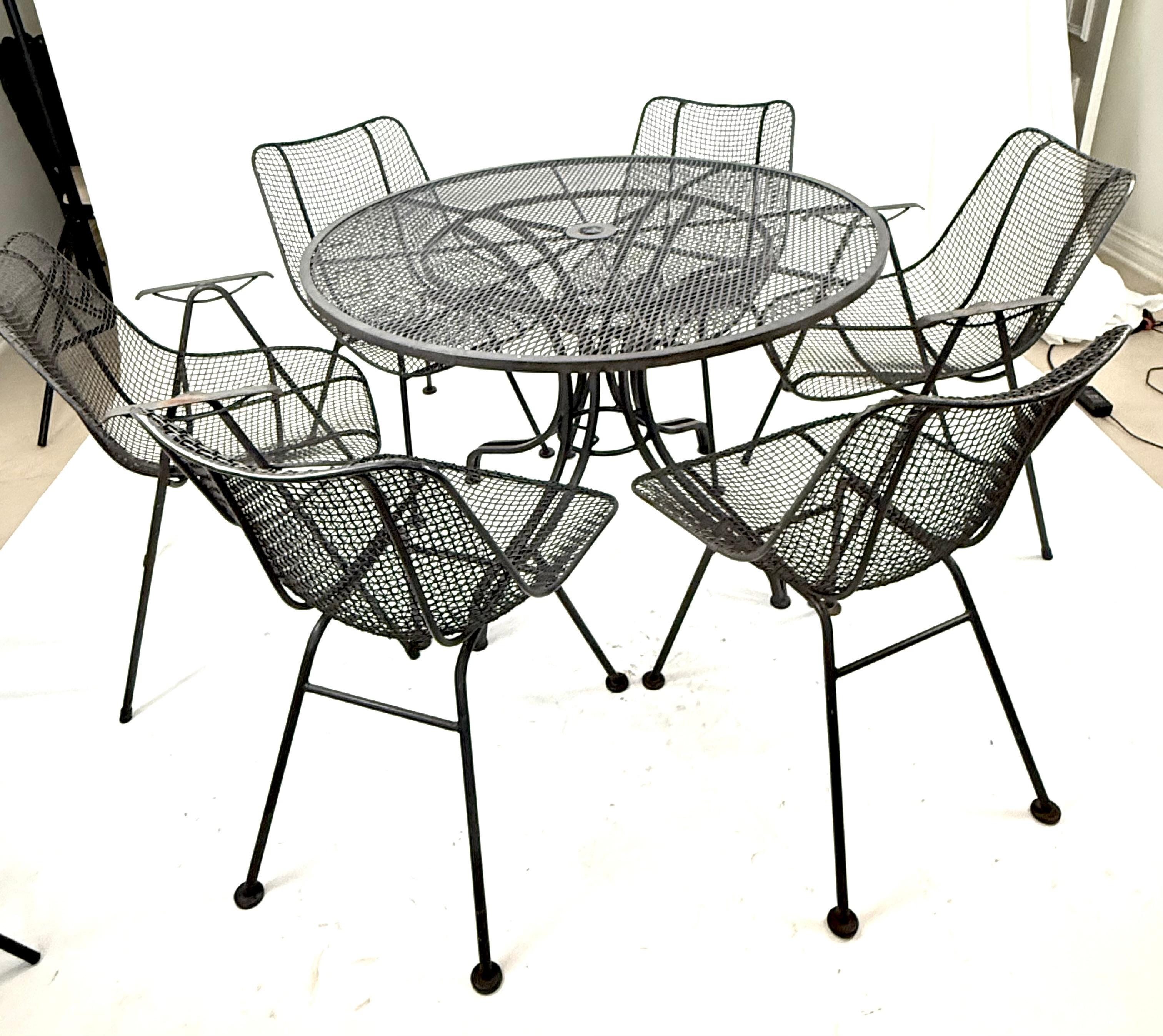 Handsome mid century set - perfect for poolside!  Armchairs have rubber tip glides, 4 armless chairs have iron glides. Weld contacts are durable and sturdy. Designer of table is unknown, and not thought to be Russell Woodard but is heavy and