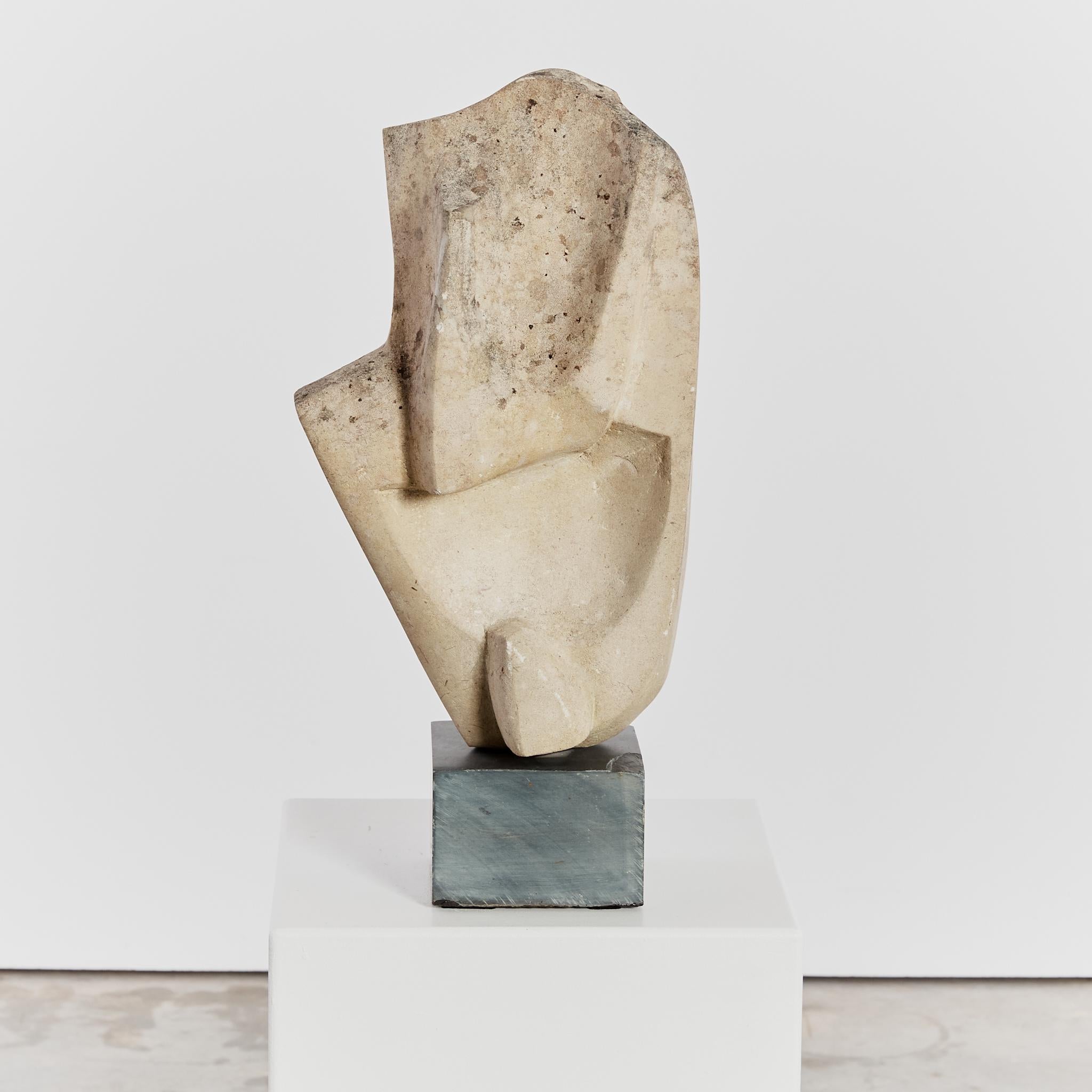 Scultura modernista di grandi dimensioni ricavata da un unico pezzo di pietra arenaria danneggiata dagli agenti atmosferici, con una forma angolare e montata su un basamento di granito. 
In passato faceva parte della collezione personale di Mollie e