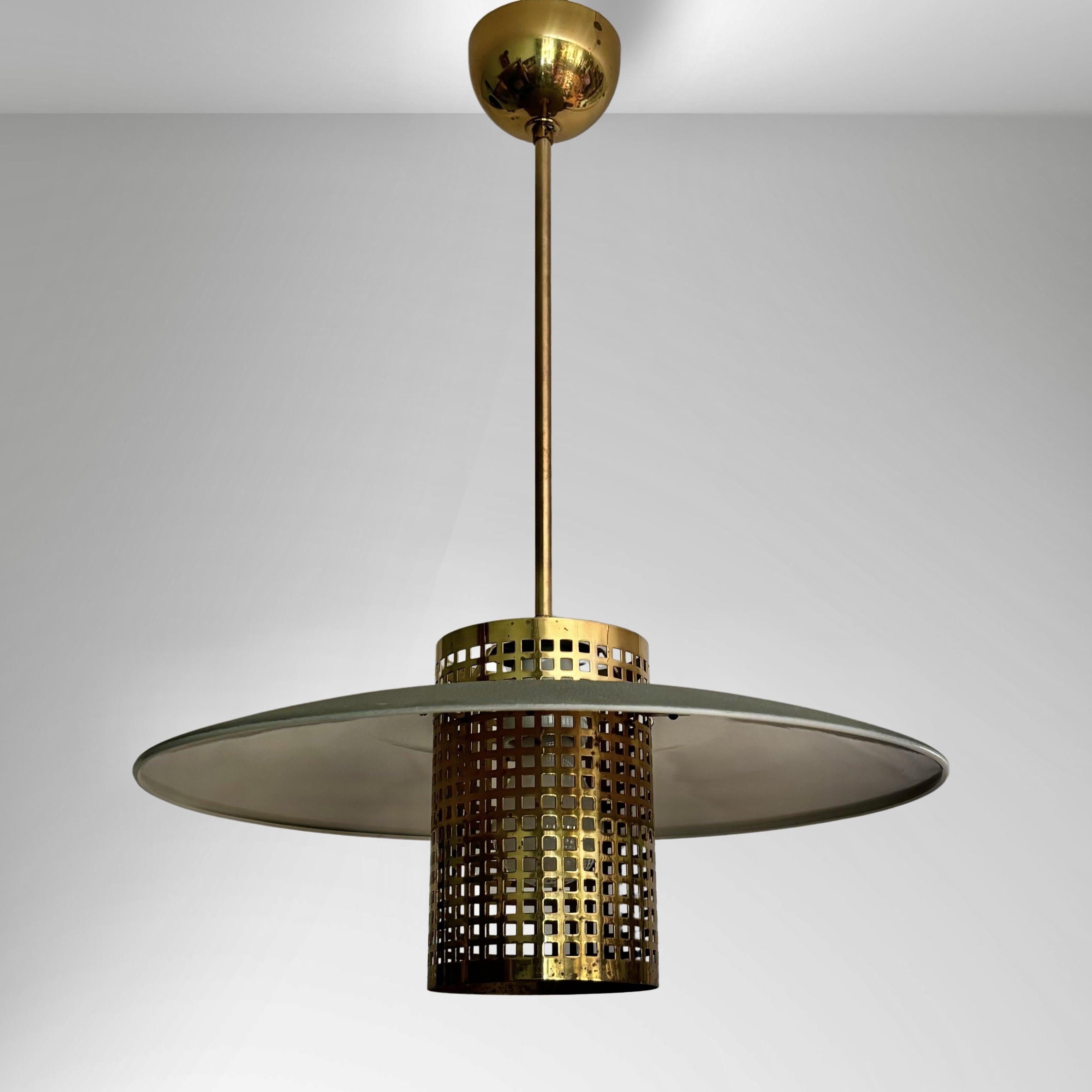 Eine seltene schwedische Pendelleuchte, Modell 54449, hergestellt von der renommierten Beleuchtungsfabrik Malmö Metallvarufabrik in den 1950er Jahren. Sie hat einen grauen oberen Schirm, der einen Zylinder aus perforiertem Messing trägt. Die Leuchte
