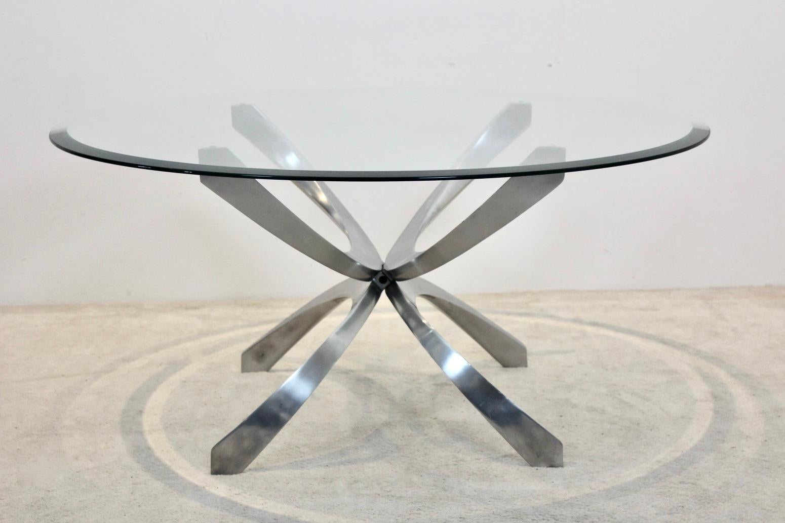 A modernist aluminum glass coffee table, was designed by Knut Hesterberg for Ronald Schmitt, Germany, 1970s. While a glass plate topped the table, the polished aluminum base shows a futuristic shape that showcases from any angle. A statement table
