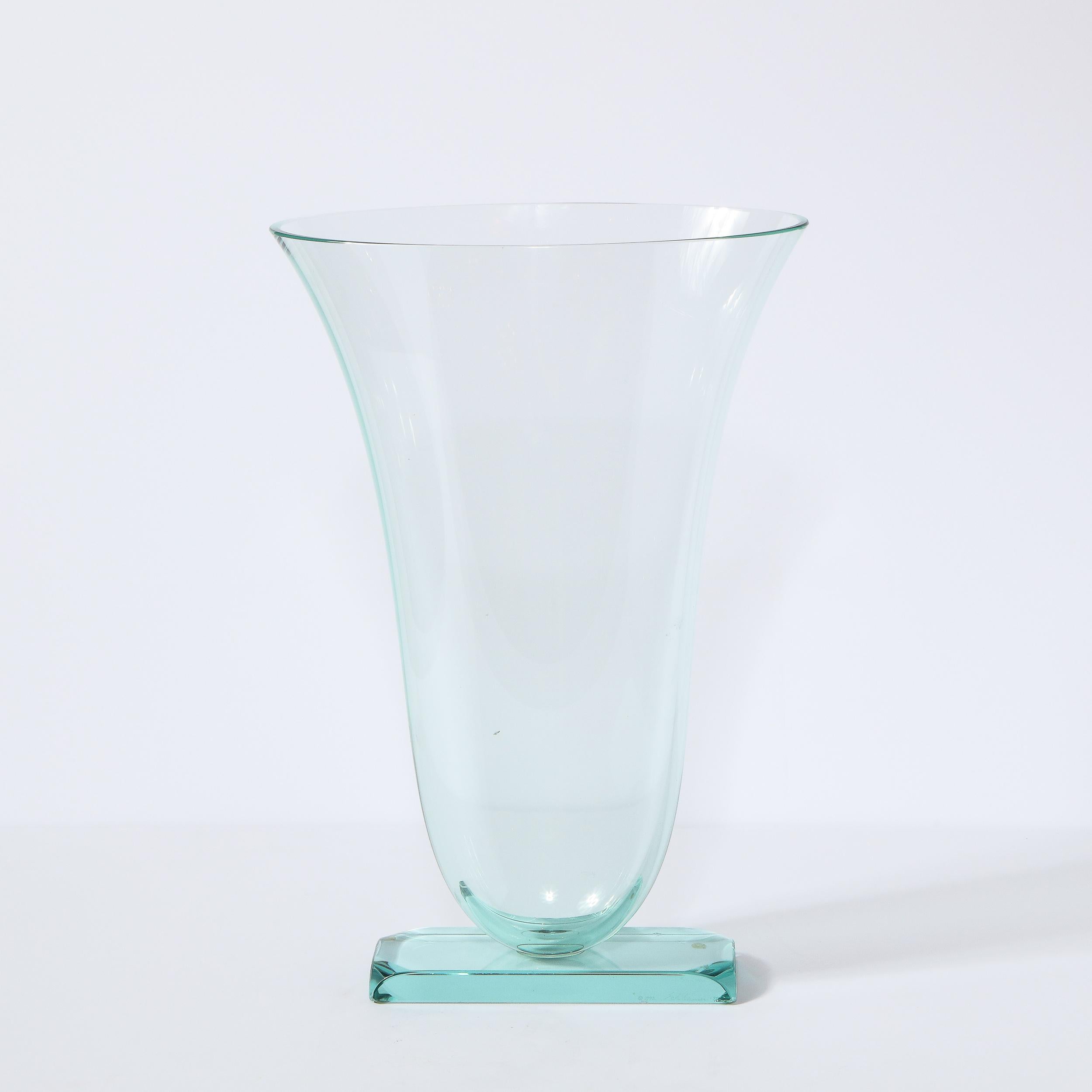 This stunning modernist sculptural vase was realized by the esteemed studio of Steven Schlanser in the United States in 1995. It features a beveled volumetric rectangular base with rounded corners from with an urn shaped body ascends with a