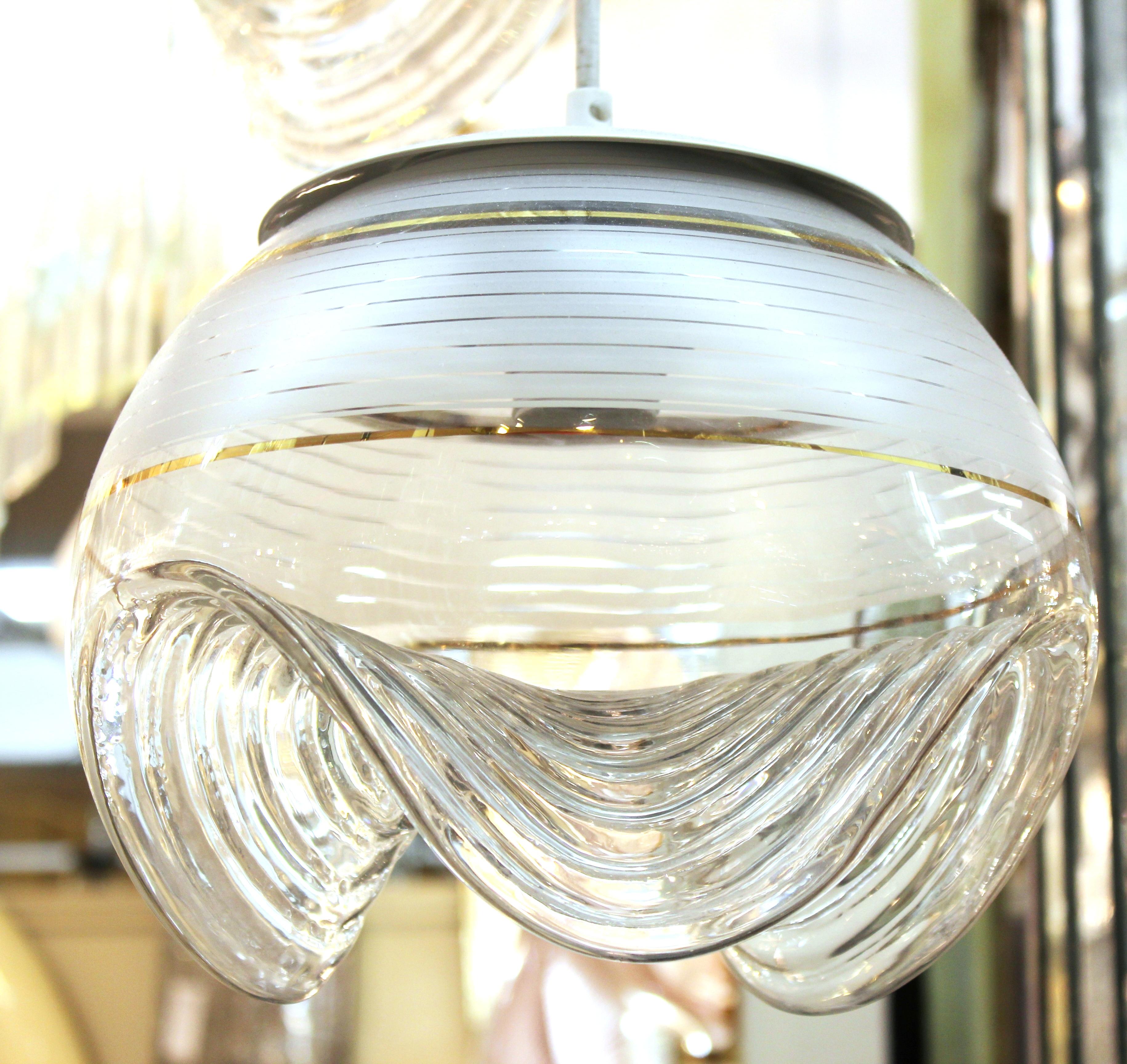 Modernist ceiling pendant light consisting of three semi-opaque sculptural glass globes with waved lower sections, hanging from a circular metal canopy piece. The piece is in great vintage condition and has recently been rewired to fit current