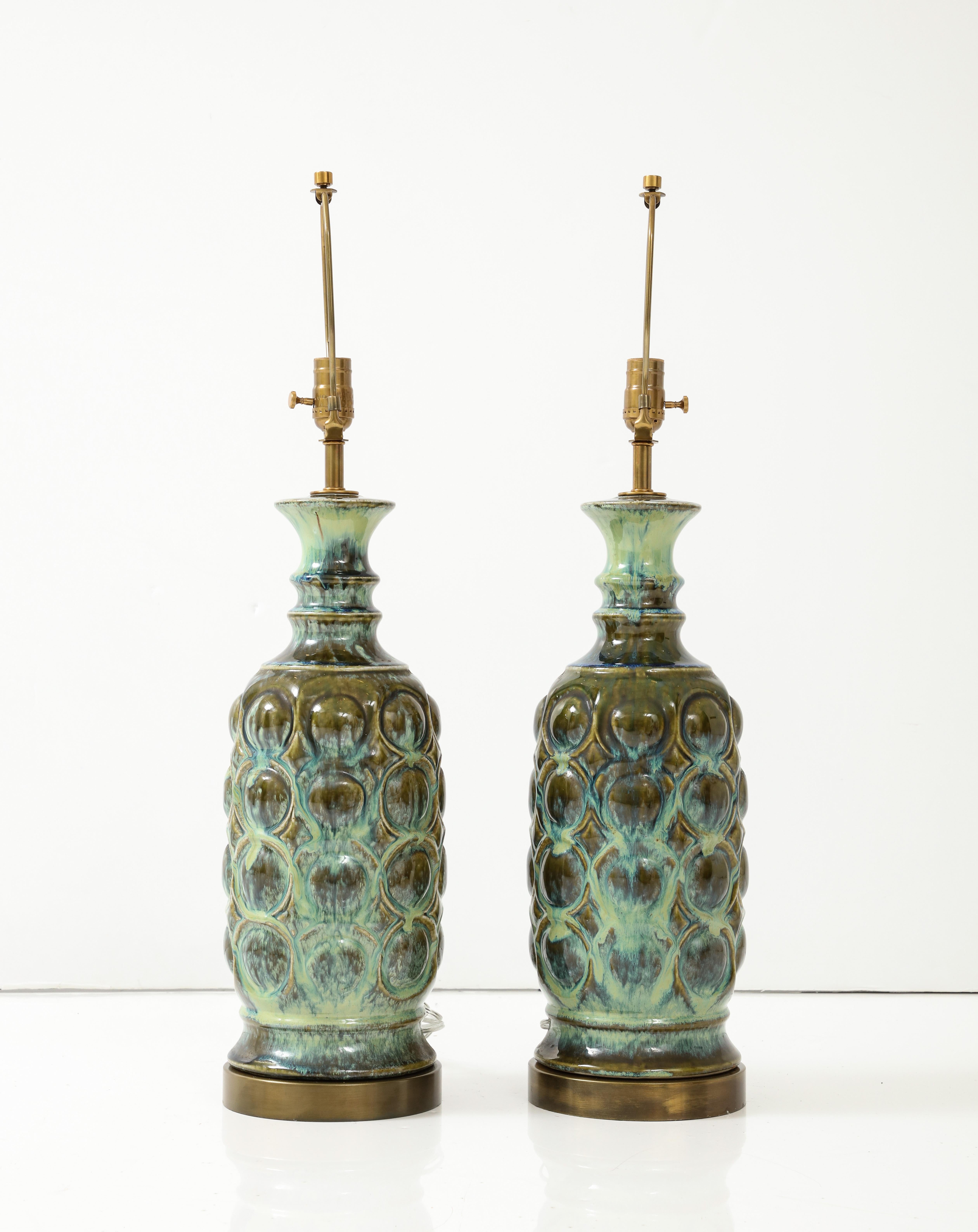 Pair of Scandinavian Modern ceramic lamps featuring a mottled blue/green glaze resting on aged brass bases. Lamps have been rewired for use in USA by an UL listed electrician. 100W bulbs max. 