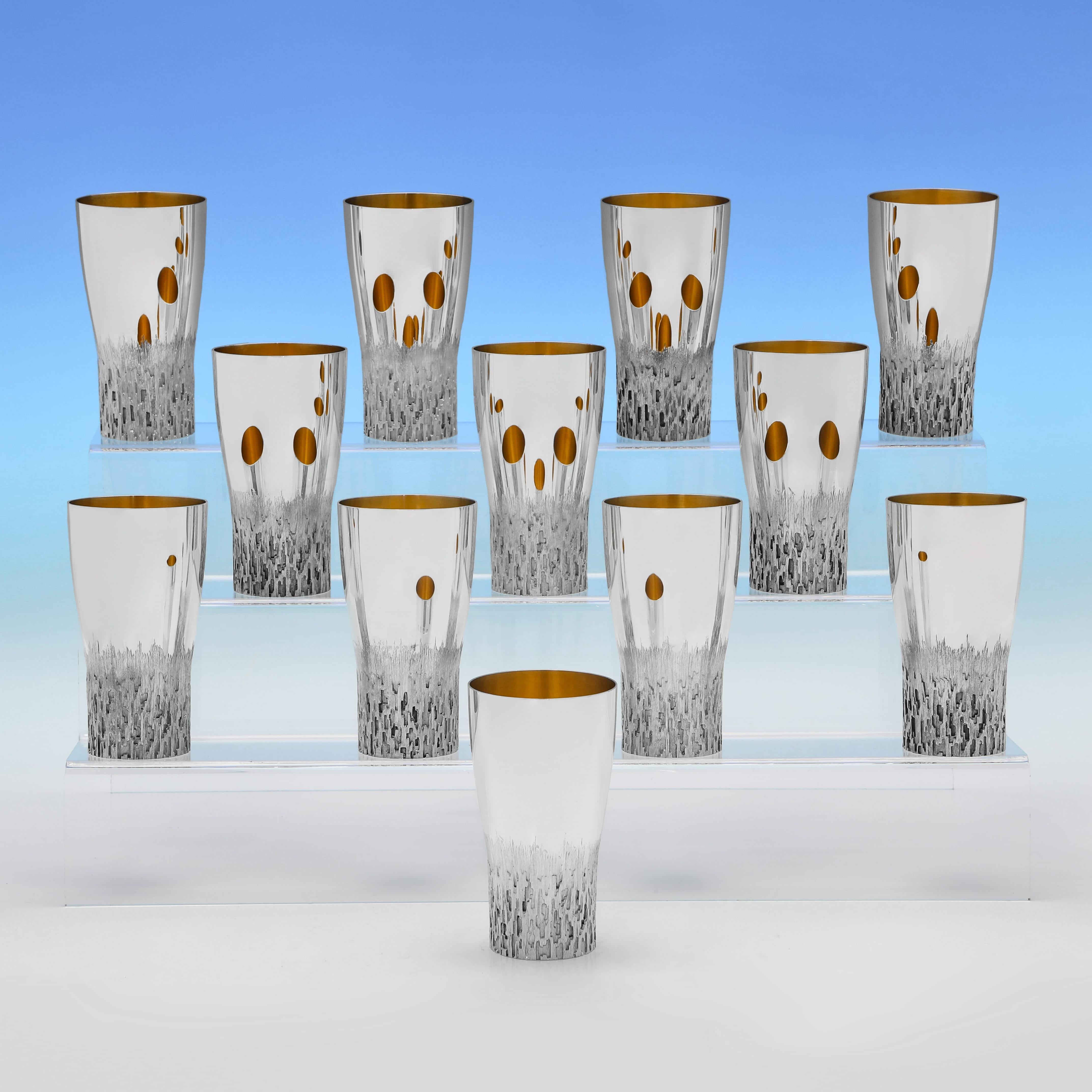 Hallmarked in London in 1972 by Christopher Lawrence, this stunning, Elizabeth II period, Sterling Silver Set of 12 Beakers & Tray, are incredibly stylish, made in Lawrence's signature style with bark effect detailing and gilt interiors. Each beaker