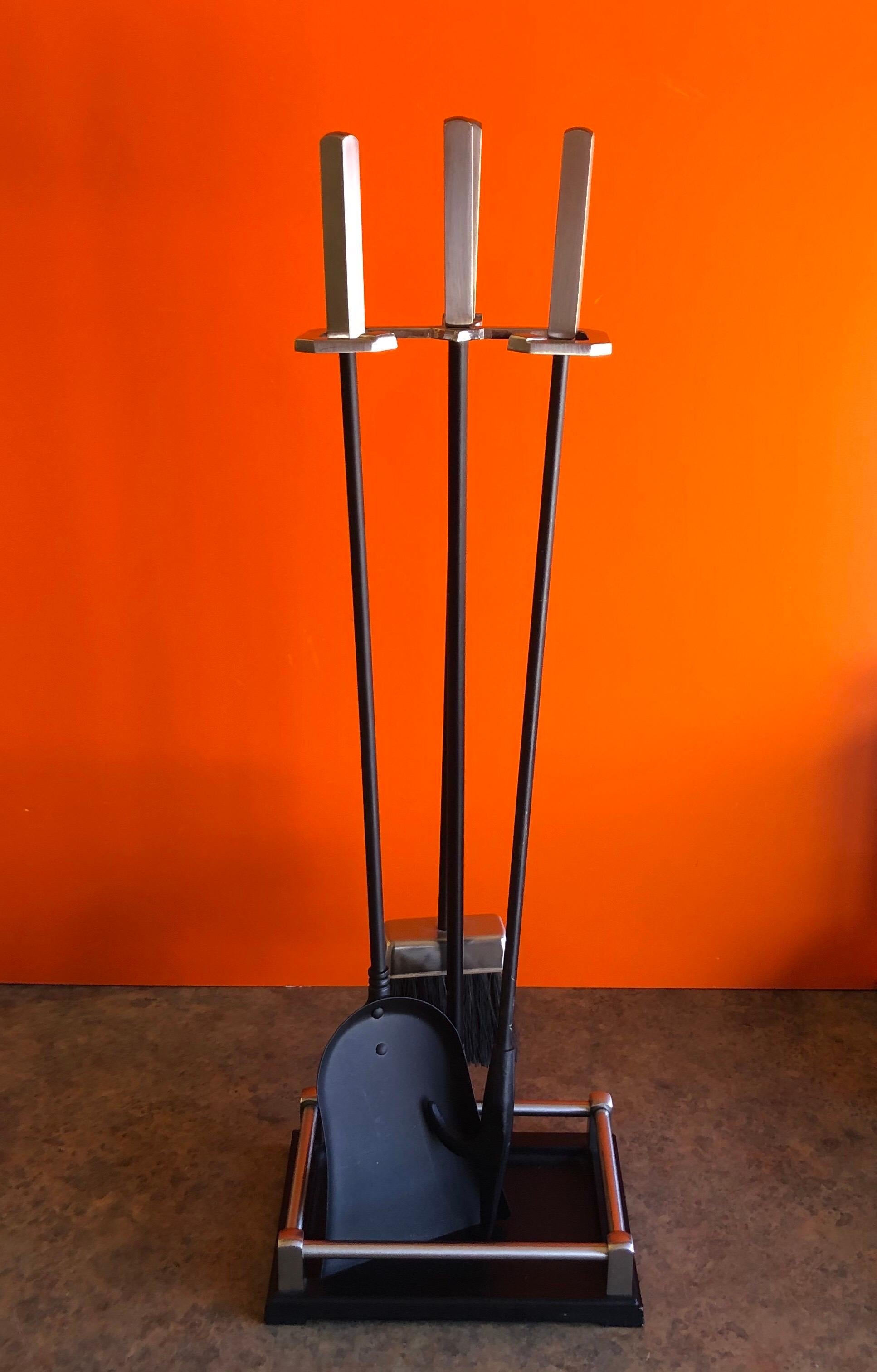 Modernist set of fire place tools with stainless steel handles, circa 1980s. There are three tools (shovel, brush and poker) and a single column stand in very good vintage condition. The set measures: 28