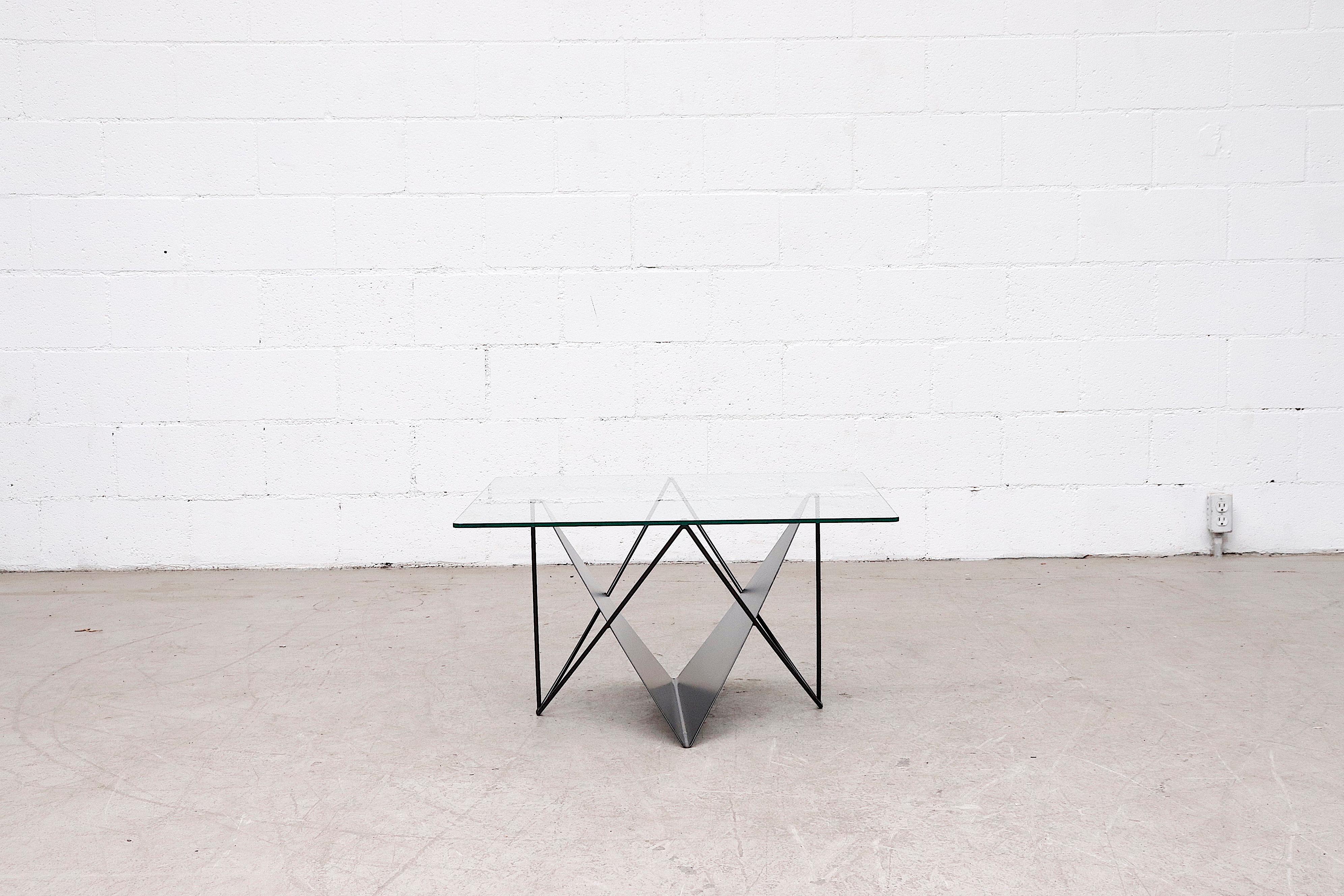 Modernist side or coffee table with glass top, black enameled sheet metal magazine rack and matching enameled wire frame. In original condition with moderate wear consistent with age and use.