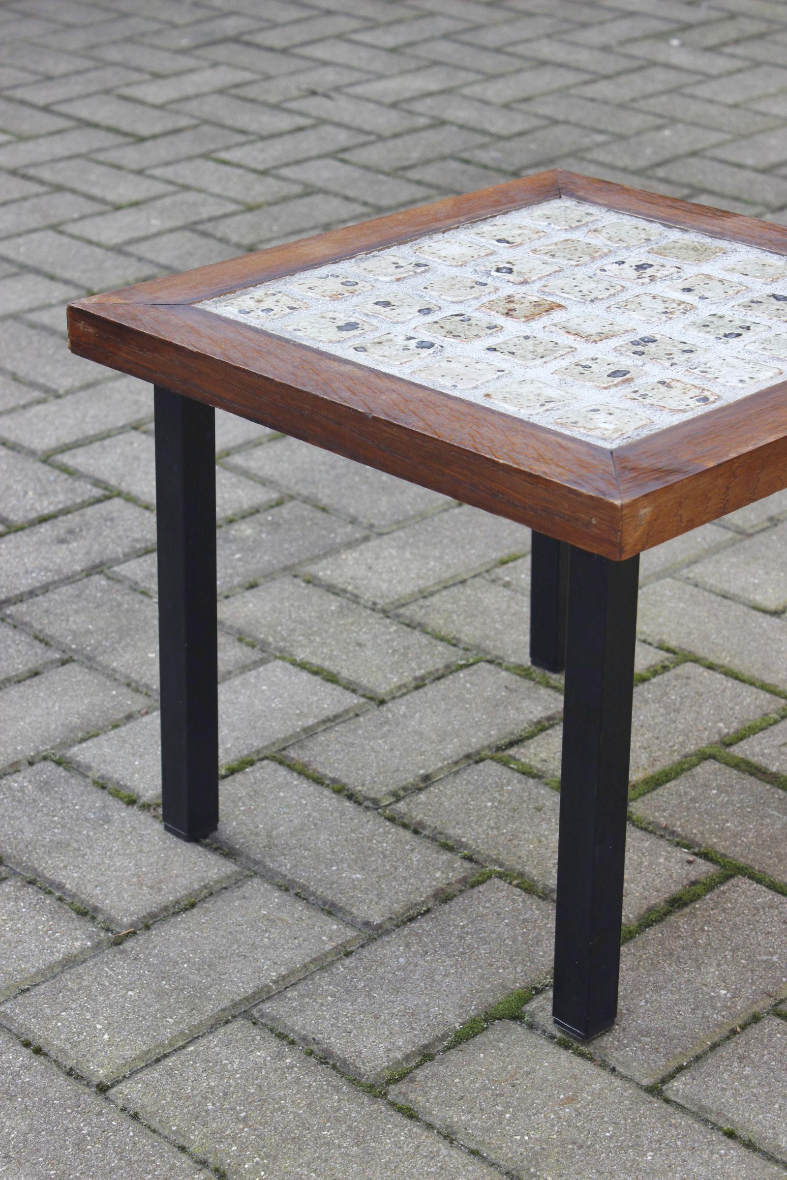 Beautiful side table circa 1950, the top is in concrete and sandstone tiles with pyrite enamel on soft brown tones, in a dark brown solid wood frame, all resting on four black painted steel legs. 

Unidentified modernist style production from