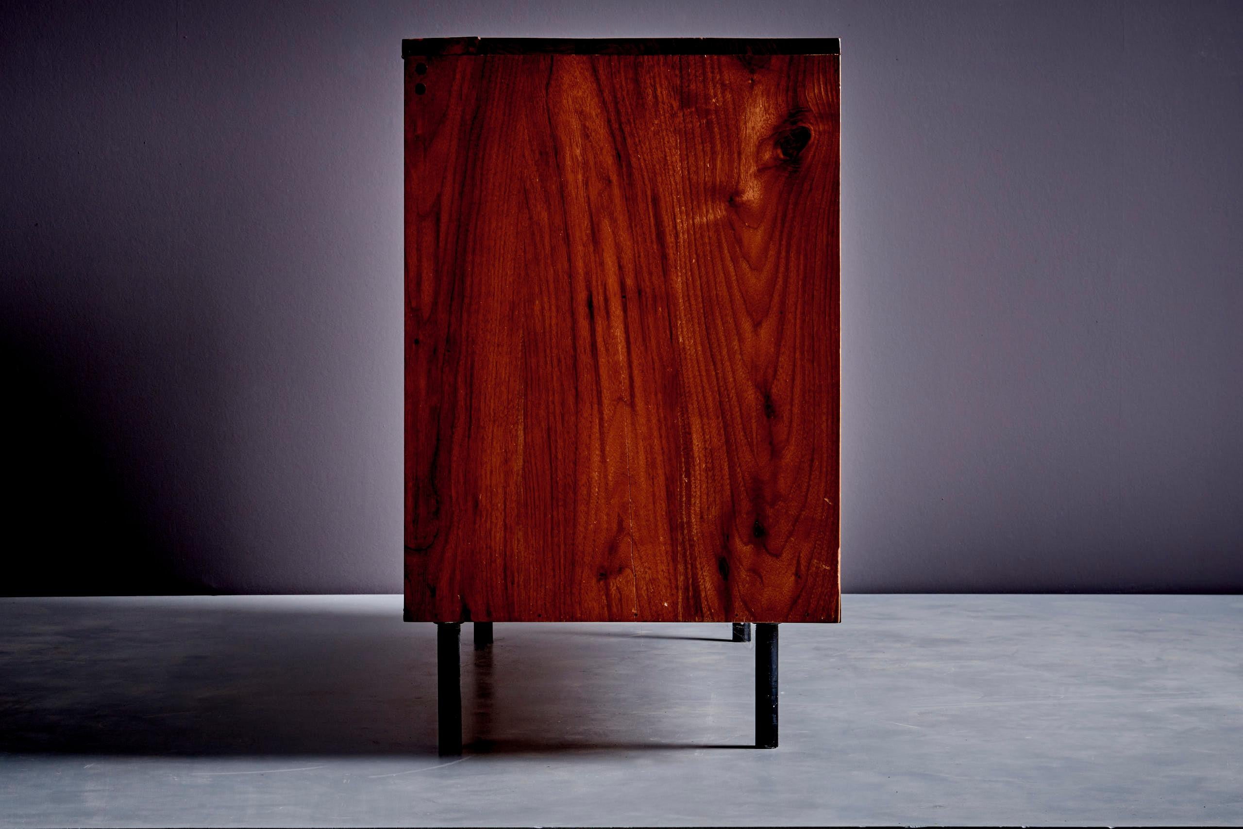Questa credenza in noce è stata progettata da Allan Gould negli Stati Uniti negli anni Sessanta. Ha un aspetto molto pulito e moderno, senza maniglie: i cassetti si aprono facilmente attraverso piccole fessure sui lati. Il movimento dei cassetti è