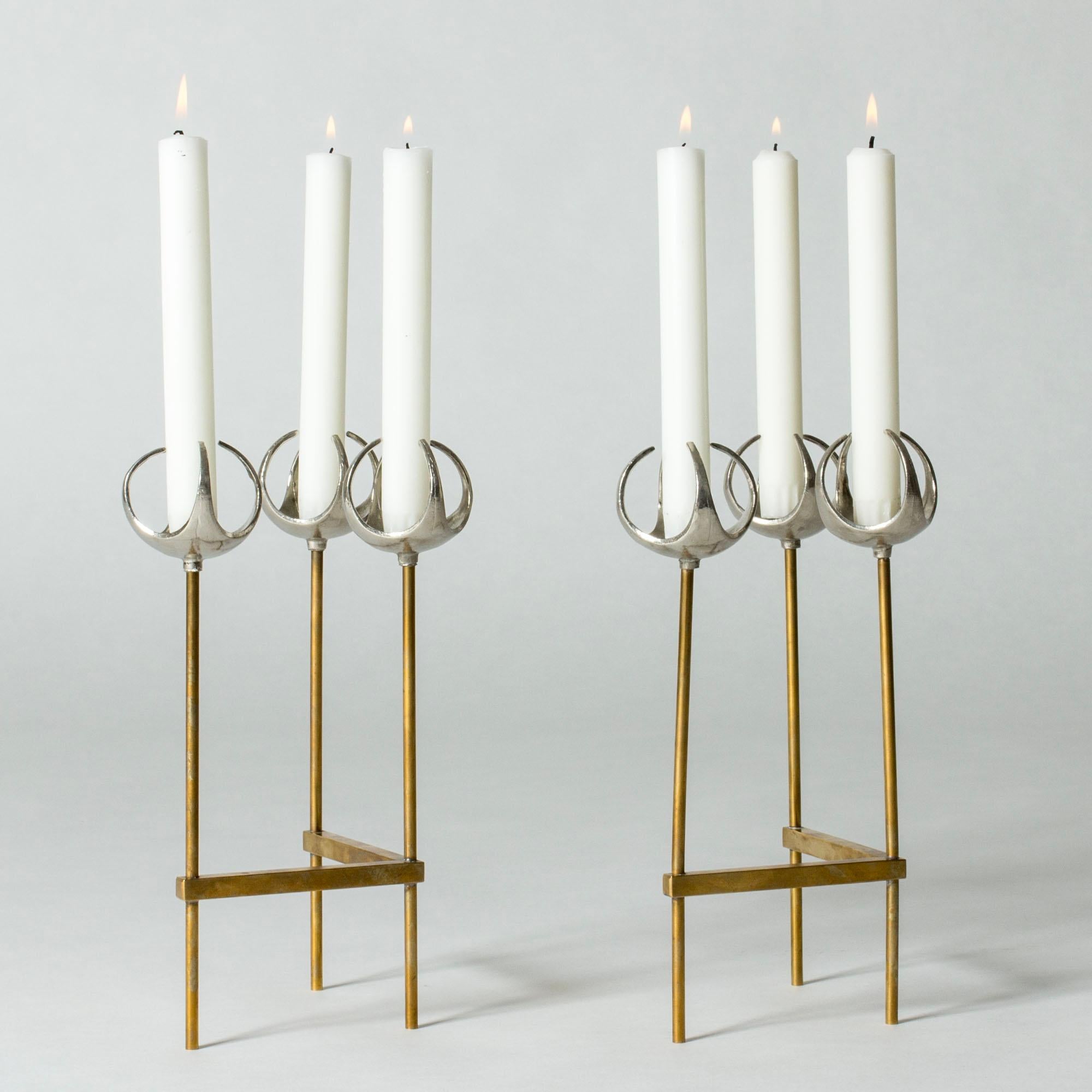 Paire de magnifiques chandeliers en bronze et argent par Olof Barve, dans un design qui allie le minimalisme graphique à une expression organique. L'angle de 90 degrés de chaque chandelier permet de disposer la paire de plusieurs façons.