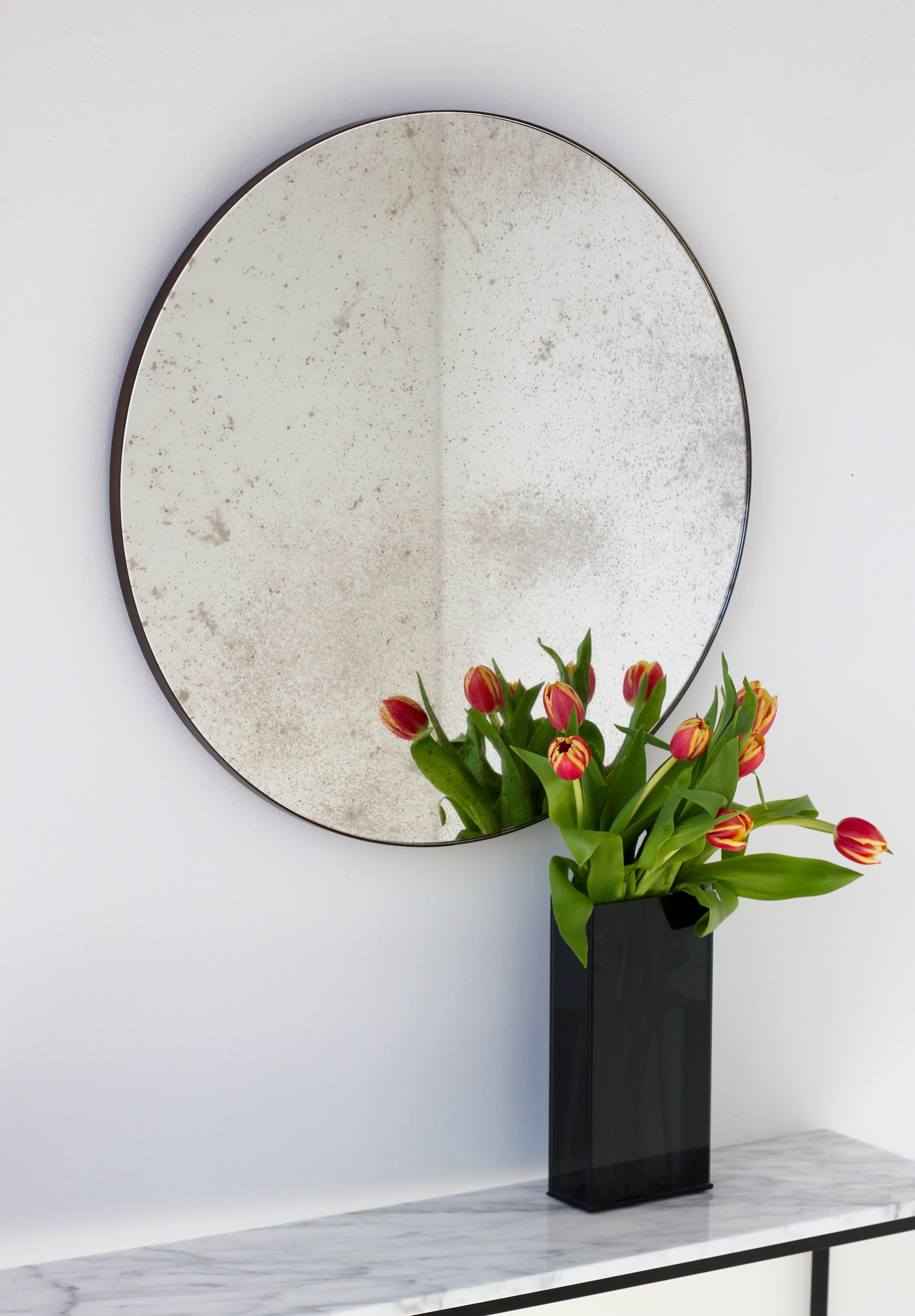 Art Deco style antiqued Orbis™ round mirror with a minimalist bronze patina brass frame. Designed and handcrafted in London, UK.

Our mirrors are designed with an integrated French cleat (split batten) system that ensures the mirror is securely