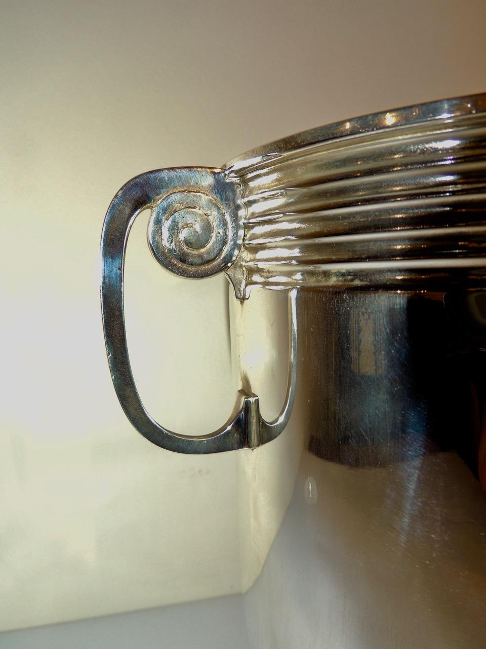A sleek, modernist, French silver plate champagne cooler with unusual spiral detail handles. Another accent is the matching bands at the top and bottom of the piece. This is heavily plated, recently restored and in great condition both inside and