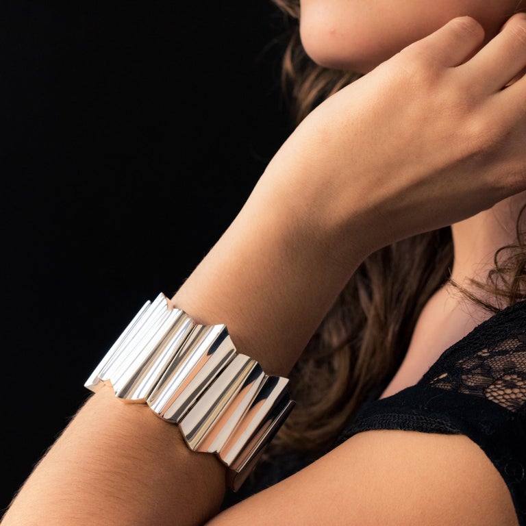 Bracelet in silver.
Important and massive, this silver cuff is made up of patterns with geometric and convex lines hinged together. The bracelet is semi rigid and closes with a hinge and a safety ratchet.
Inner circumference: 17 cm, width: 4.5 cm