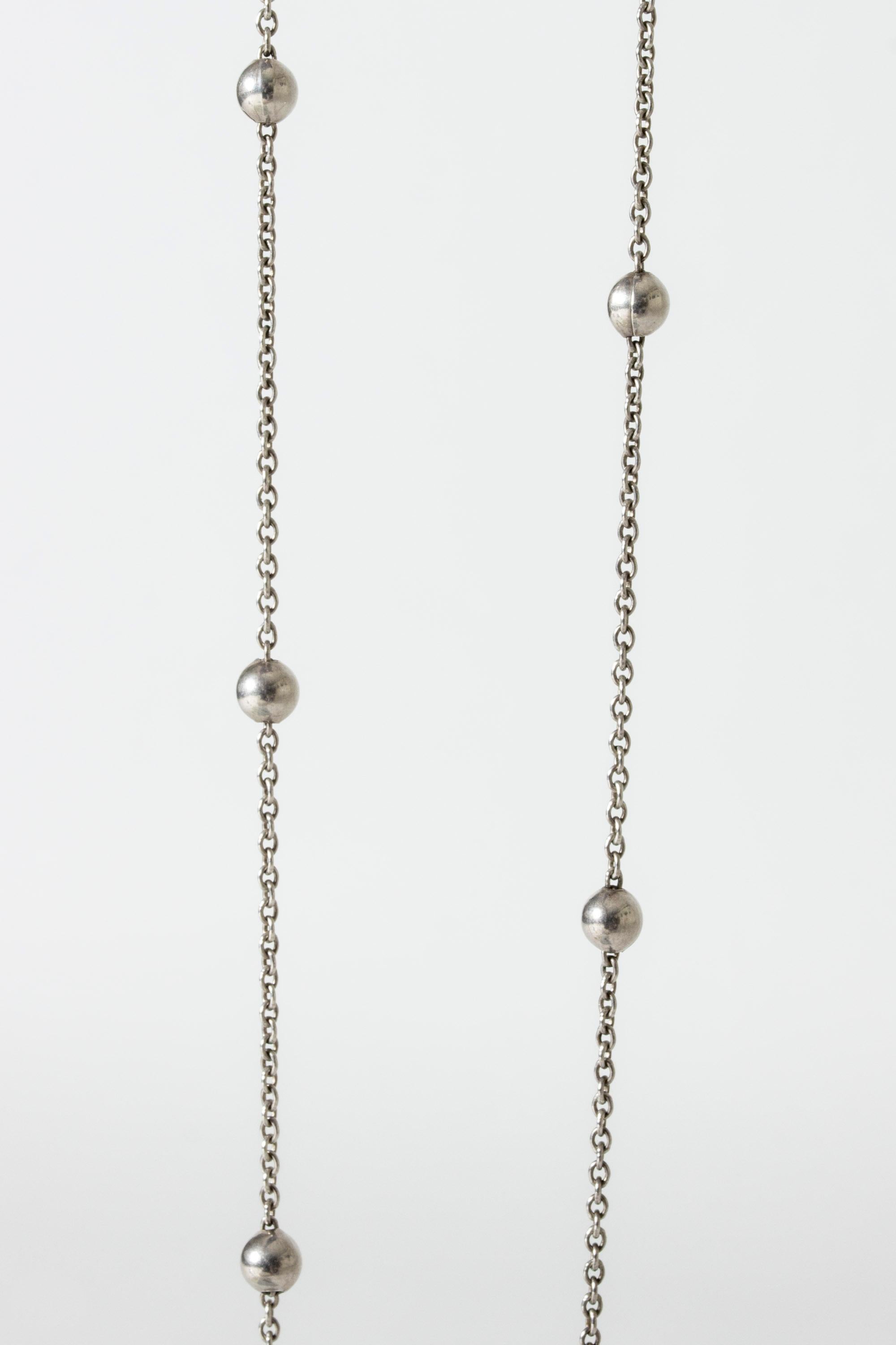 Joli collier en argent de Kaunis Koru, au design long et fin. Chaîne alternée avec des 