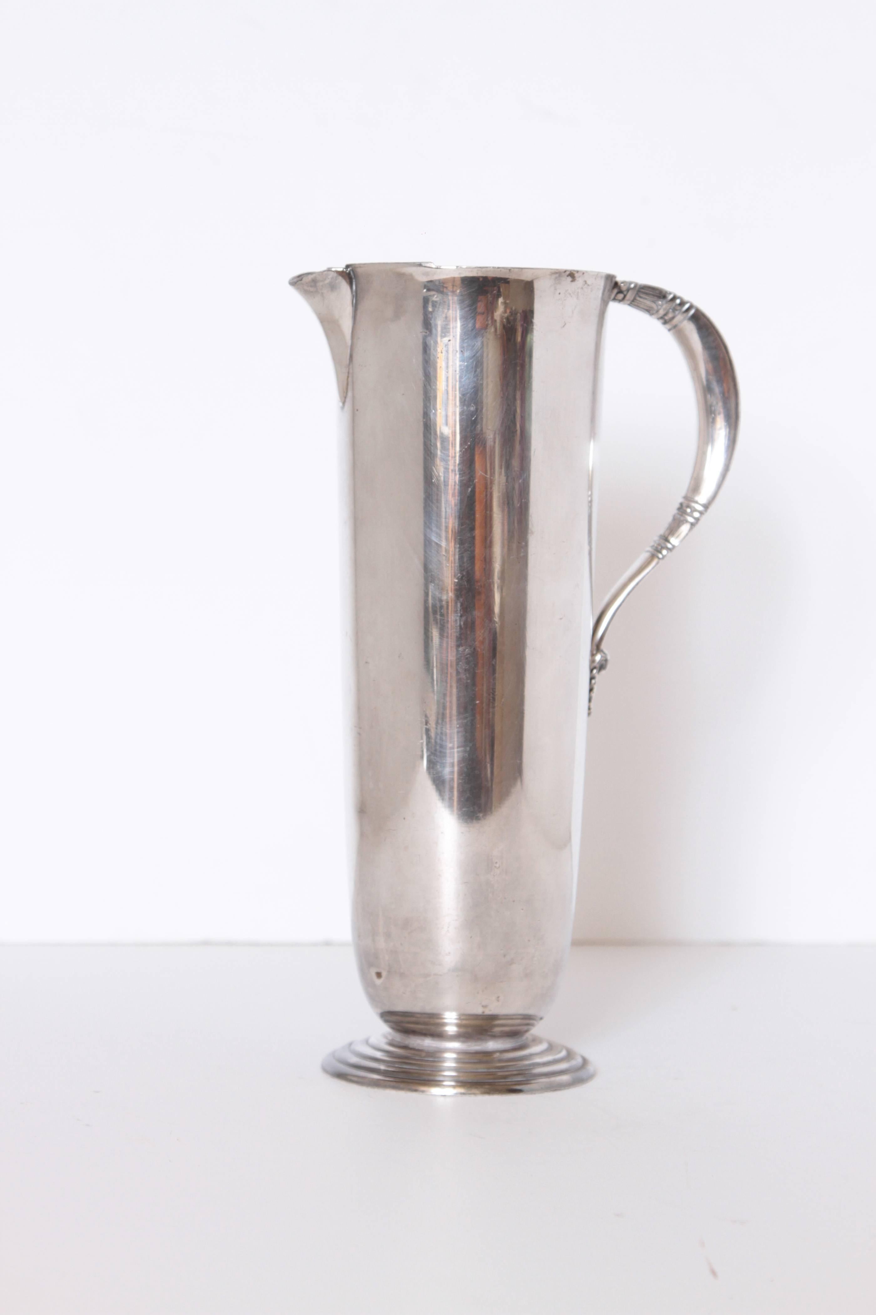 Modernist silver plate pitcher Carl Conrad Braun International silver tropical

Art deco machine age cocktail mixing pitcher by Braun for International in the Tropical pattern,
circa 1940. Signed.
Streamline stepped base and decorated