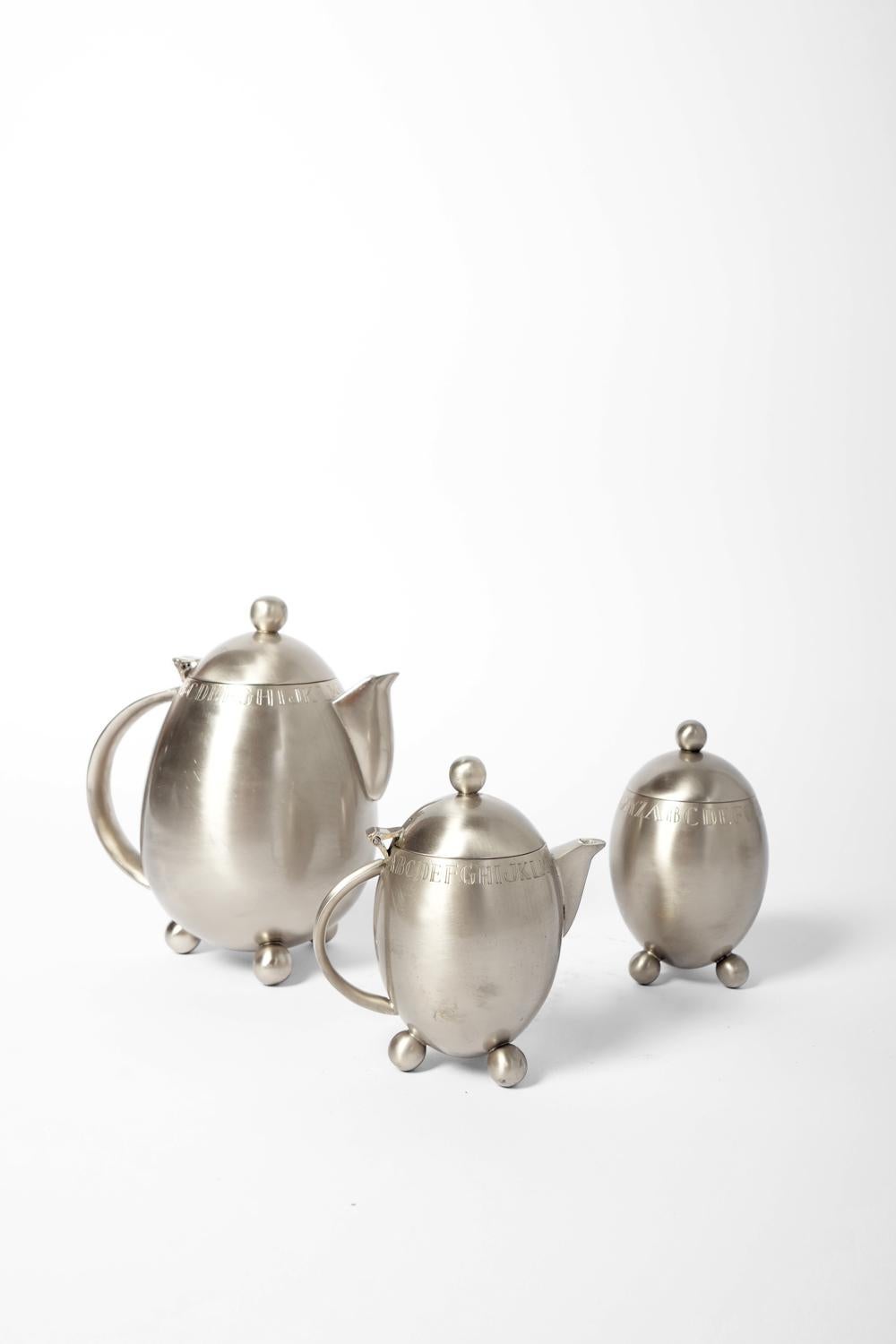 Modernist silver-plated tea service comprising a teapot, a milk jug, a sugar bowl and six cups, with engraved decoration of the letters of the alphabet around the neck. France, 1910s. 

Teapot dimensions as main reference.