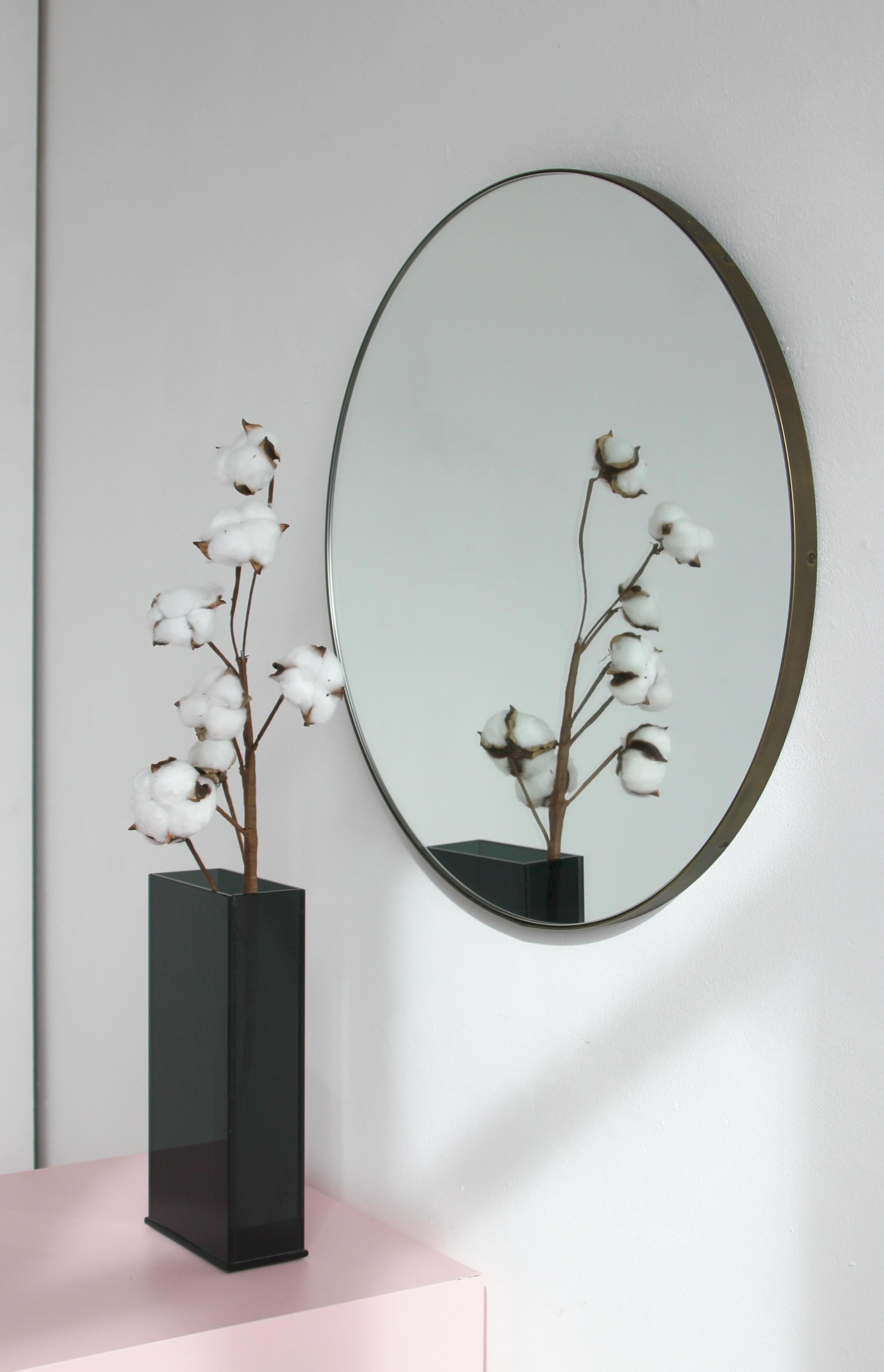 Minimalist round mirror with an elegant bronze patina brass frame. Designed and handcrafted in London, UK.

Medium, large and extra-large mirrors (60, 80 and 100cm) are fitted with an ingenious French cleat (split batten) system so they may hang