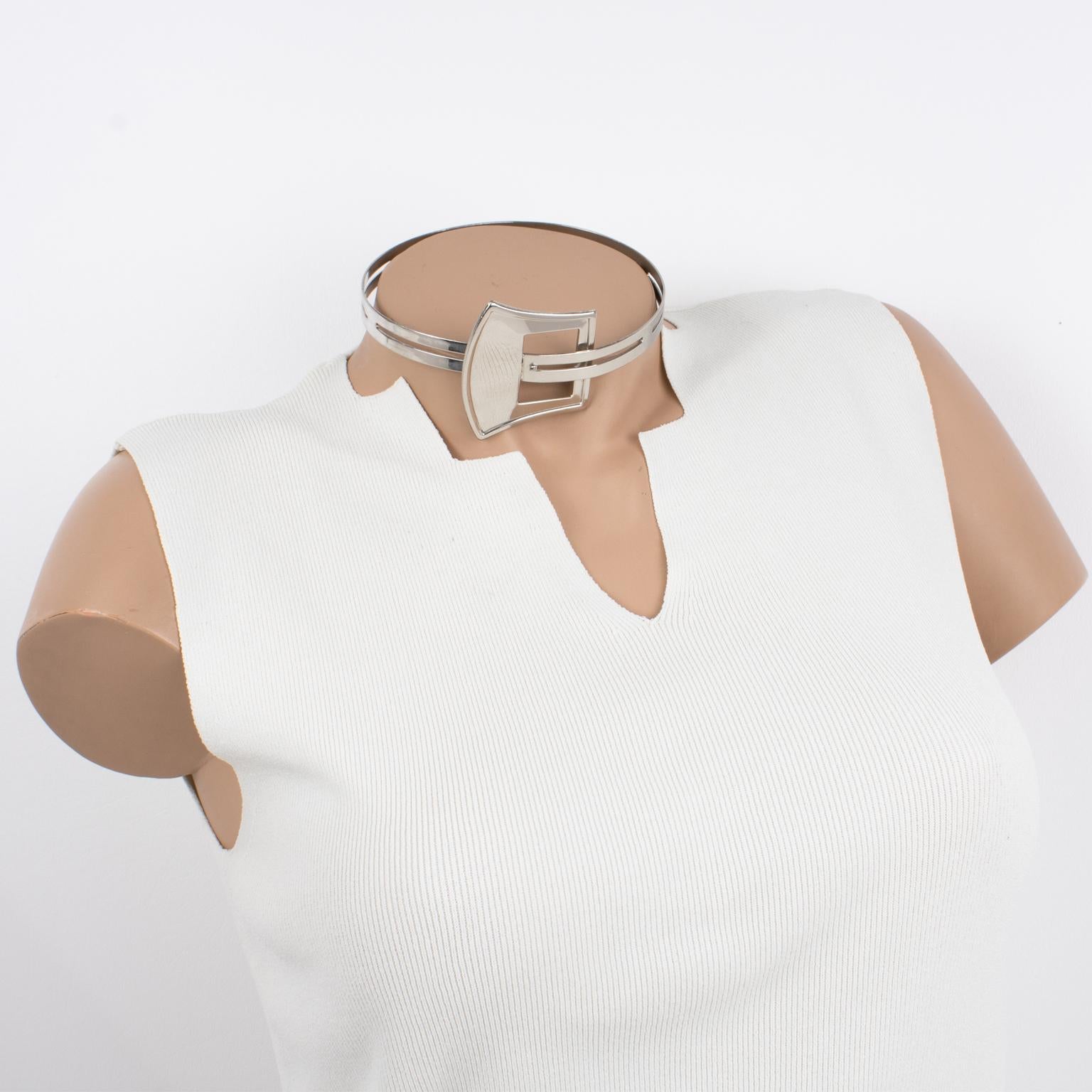 This stunning modernist rigid collar necklace boasts a silvered metal articulated neckband with metal all textured and see-thru embellished with a belt buckle design. The fastening system is hidden in the belt buckle design. There is no visible