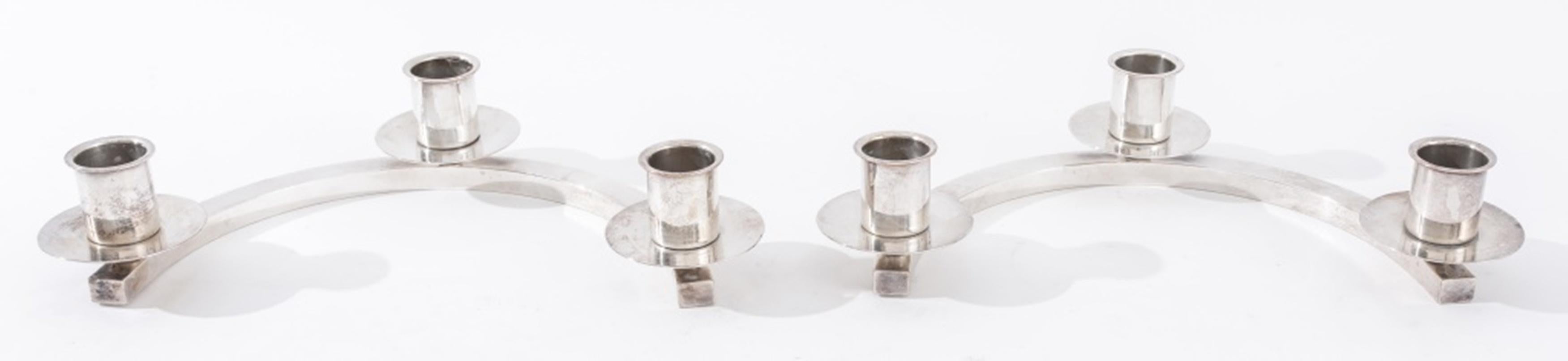 Fisher Silversmiths Modernist Silverplate Candlesticks, 2, in the manner of Norman Bel Geddes (American 1893-1958) comprising two semicircular plinths, each mounted with three candle holders with intrinsic bobeches, each with hallmark to underside