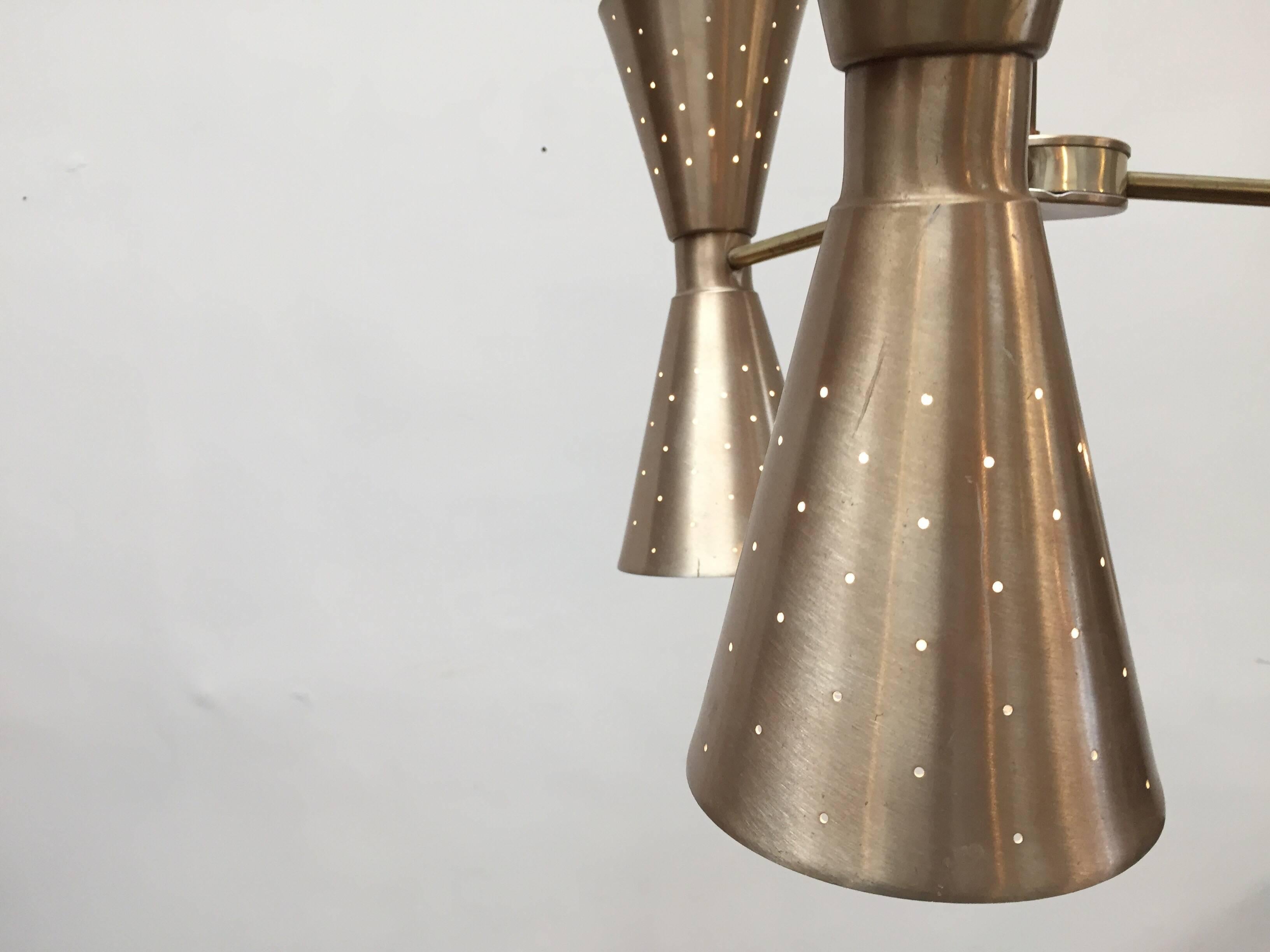 A Gerald Thurston design for Lightolier six lights arms chandelier, produced circa 1950s, with three arms, each supporting dualistic conical shades with perforated details.
Each light cone can be illuminated with the up light and the down light or