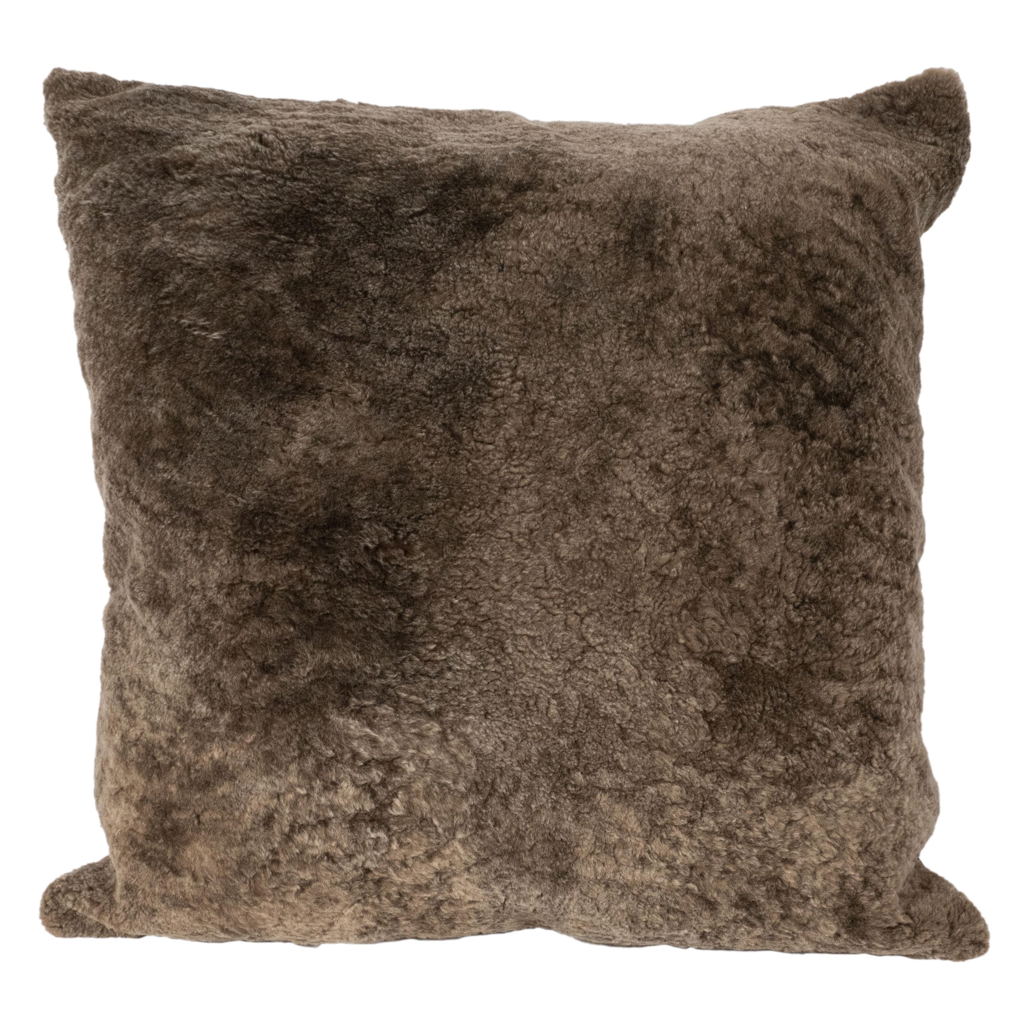 This beautiful and luxurious modernist square pillow was realized in Italy. It features a shearling front in slate umber with tawny suede. Impeccably crafted and sumptuous, this pillow would be a winning addition to any interior, and feels just as