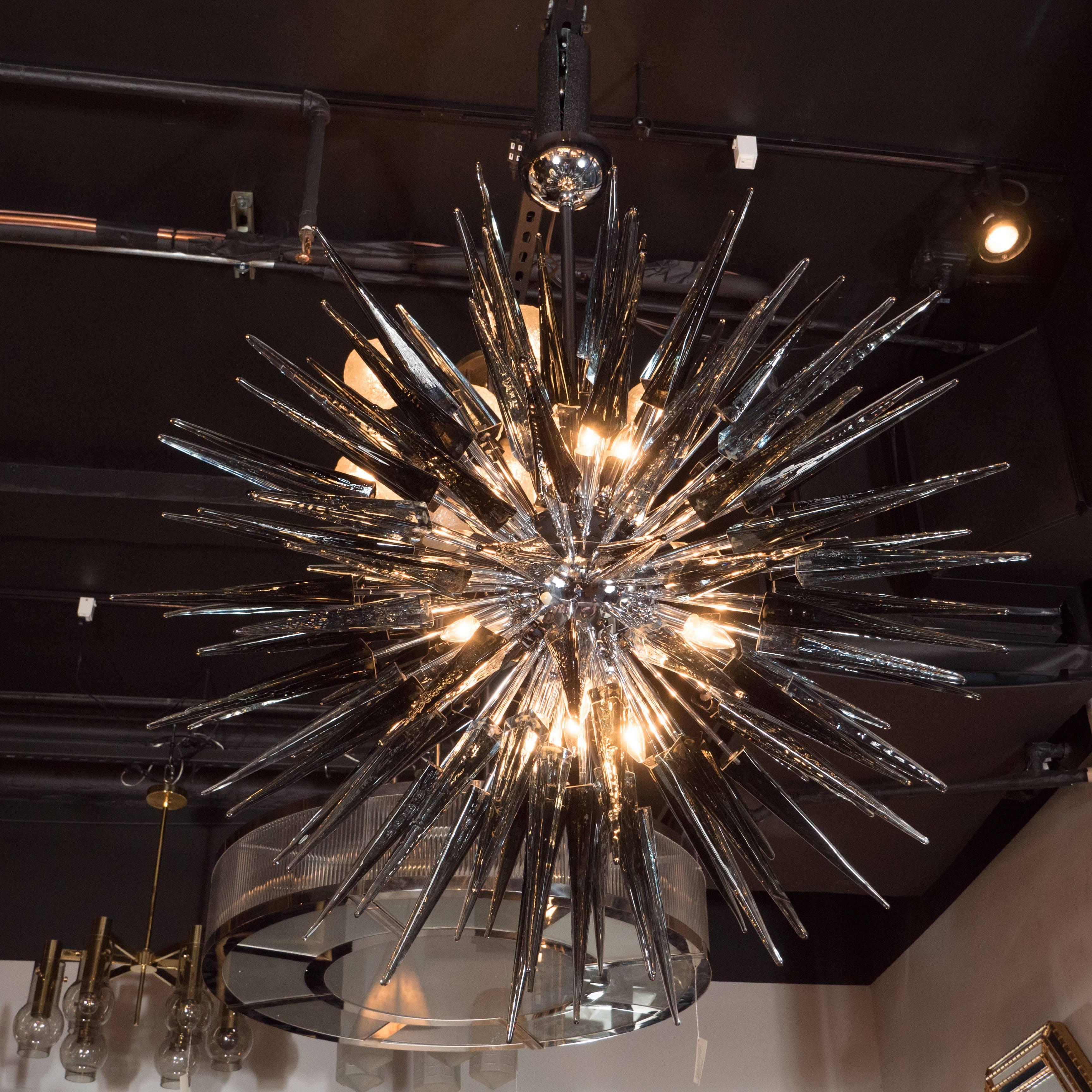 This stunning Murano glass spiked starburst chandelier was hand blown in Murano, Italy- the island off the coast of Venice renowned for centuries for its superlative glass production. The fixture offers an abundance of obelisks in hand blown smoked