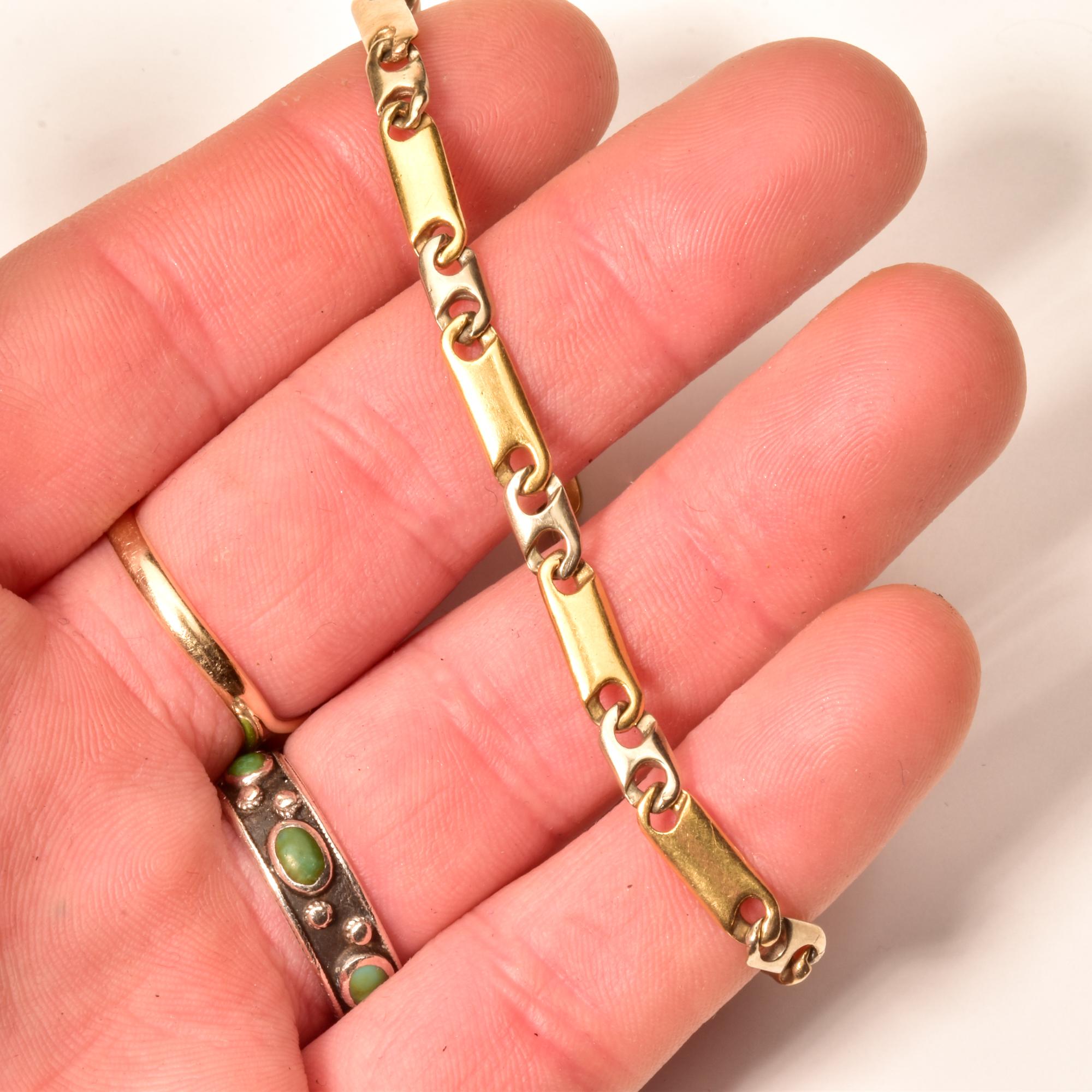 A stylish and solid 18k two-tone gold link bracelet for a modernist jewelry collection. Features a single strand of 'Gucci-style' yellow gold and white gold links with an old-style lobster claw clasp. The links look similar to a mariner chain, but