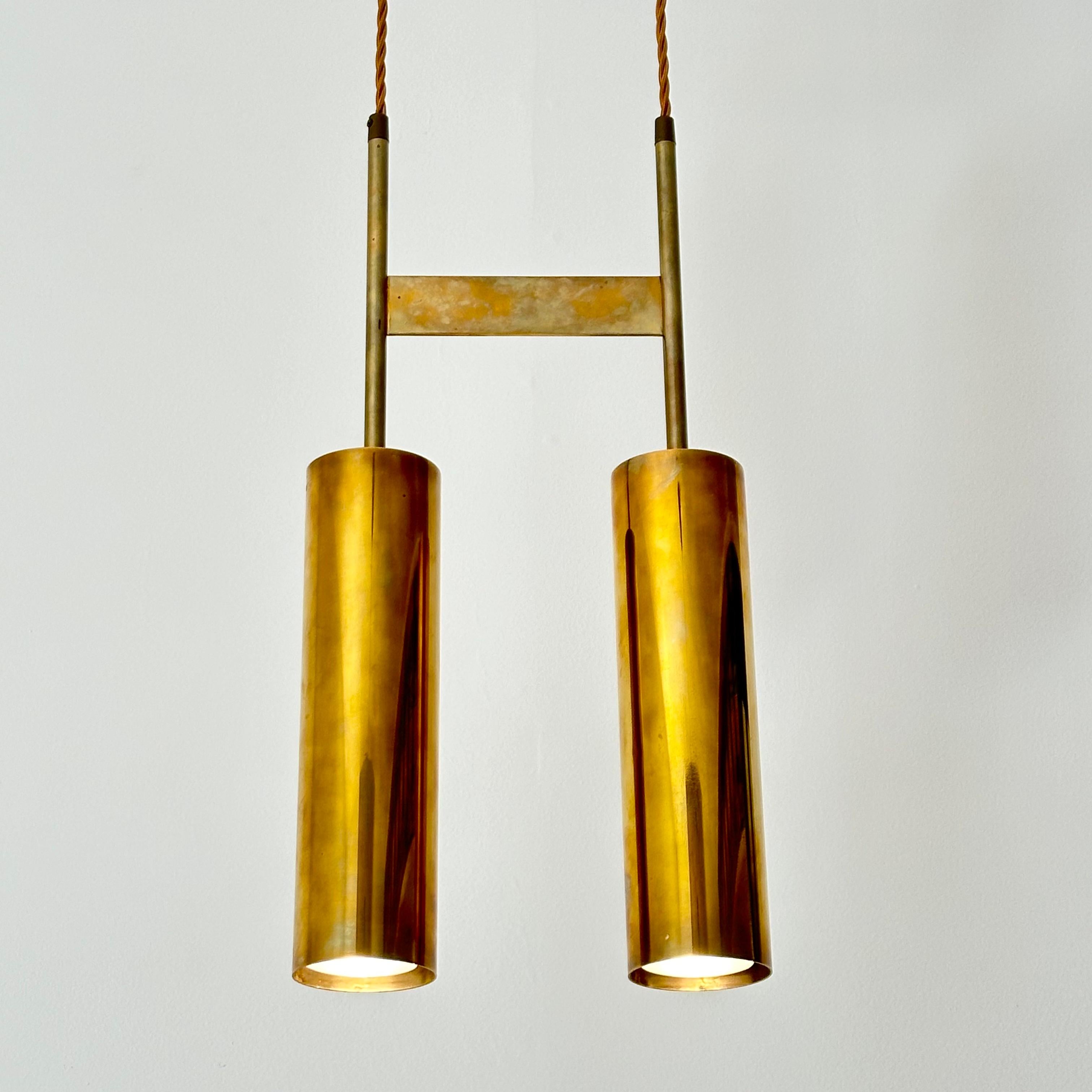 Modernist double pendant light executed in solid brass, attributed to Jo Hammerborg for Fog & Mørup. Brass is unlacquered, exhibiting natural oxidation (if desired, inquire with us regarding finishing options). Superb quality. Recently rewired,