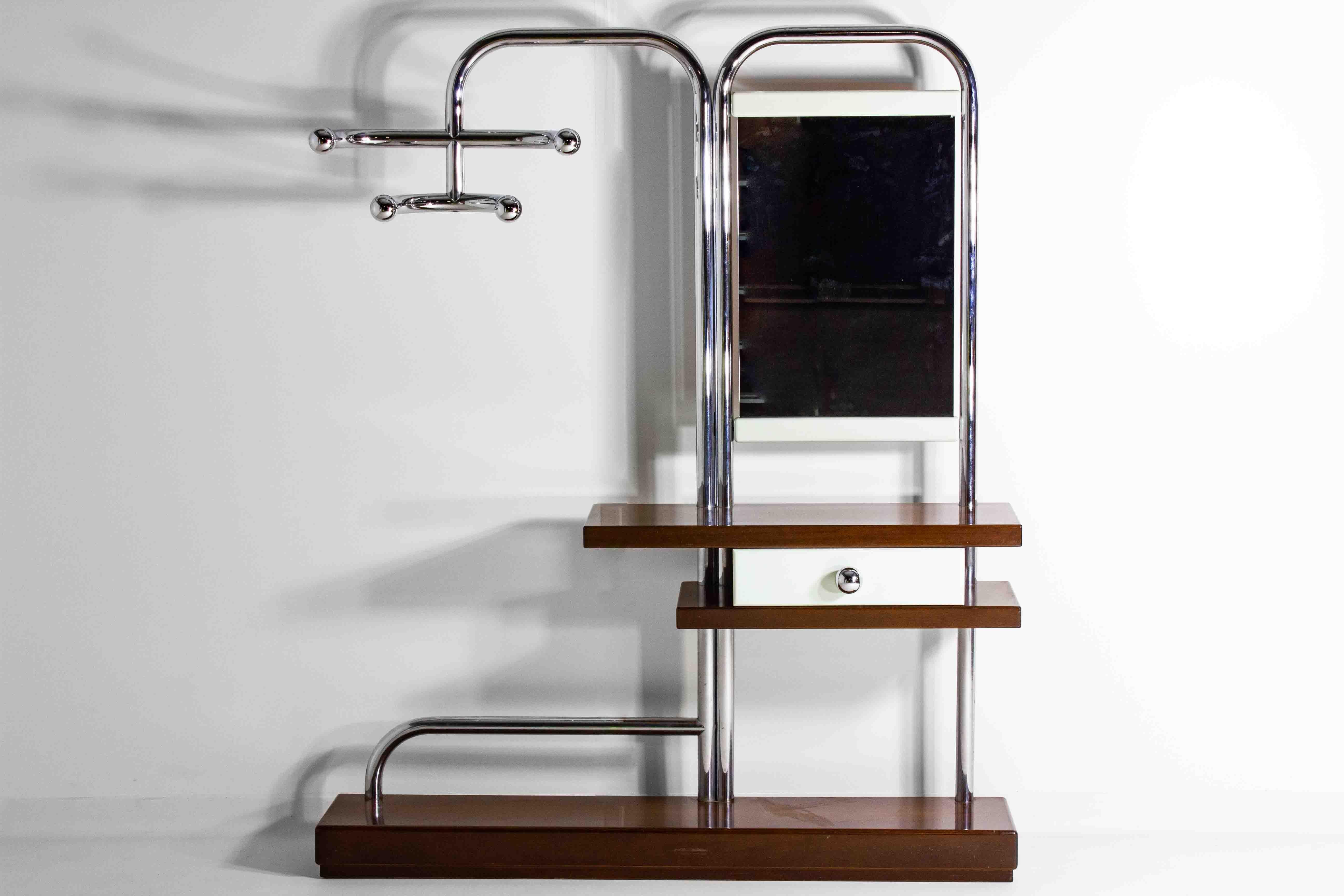 Questo incredibile appendiabiti spaziale, realizzato in legno di teak e tubi cromati, crea un'elegante apertura per il rientro a casa. È in condizioni quasi perfette. Prodotto in Italia negli anni '60