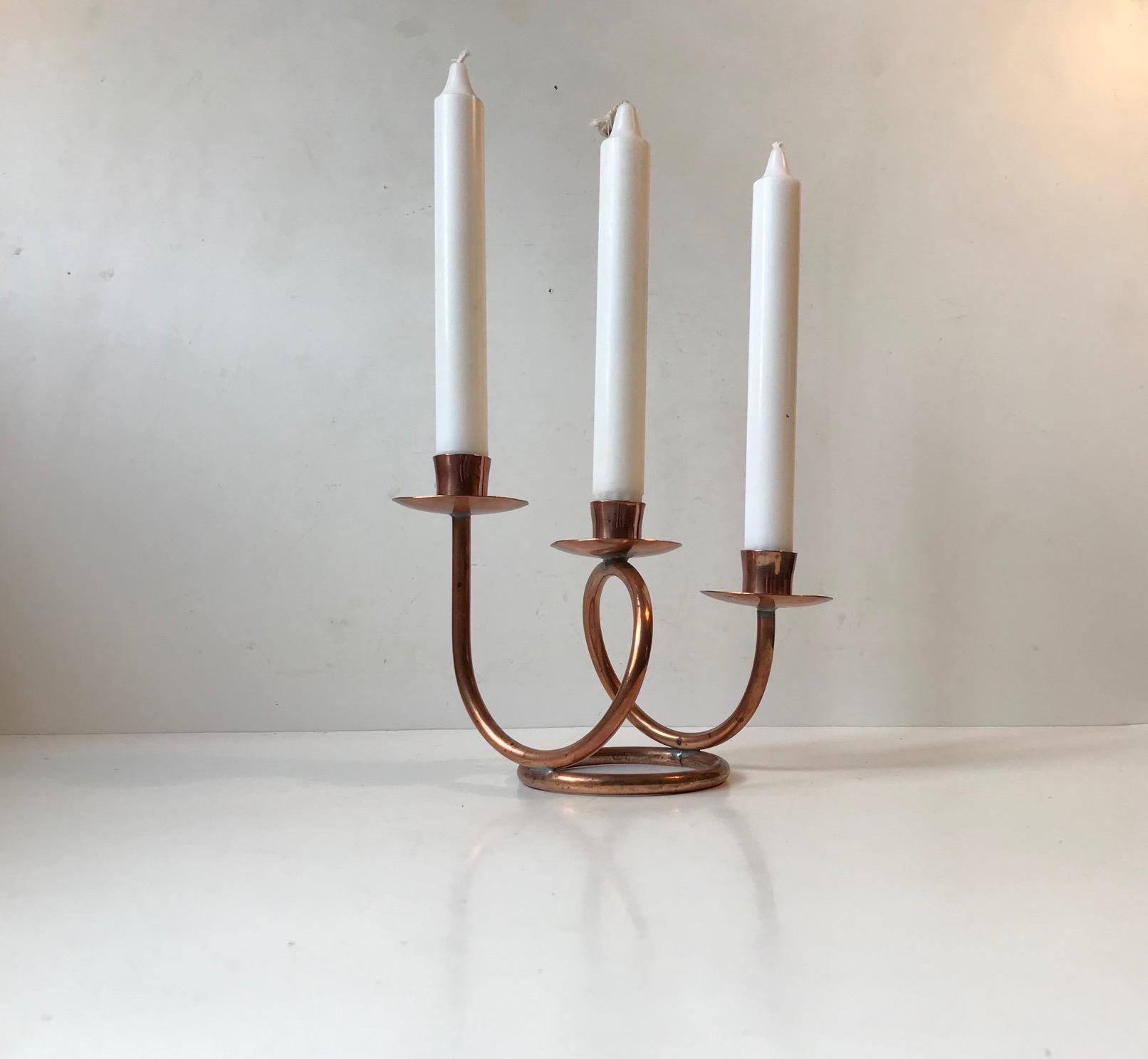 Petit candélabre unique fabriqué à partir de tubes de cuivre massif pliés. Fabriqué à la main dans un petit atelier de Hejl, au Danemark, dans les années 1970. Il doit être installé avec des bougies de taille normale.