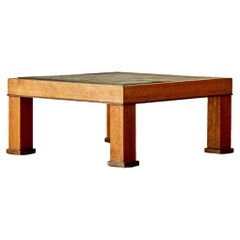Table basse carrée moderniste avec plateau en ardoise et base en chêne.