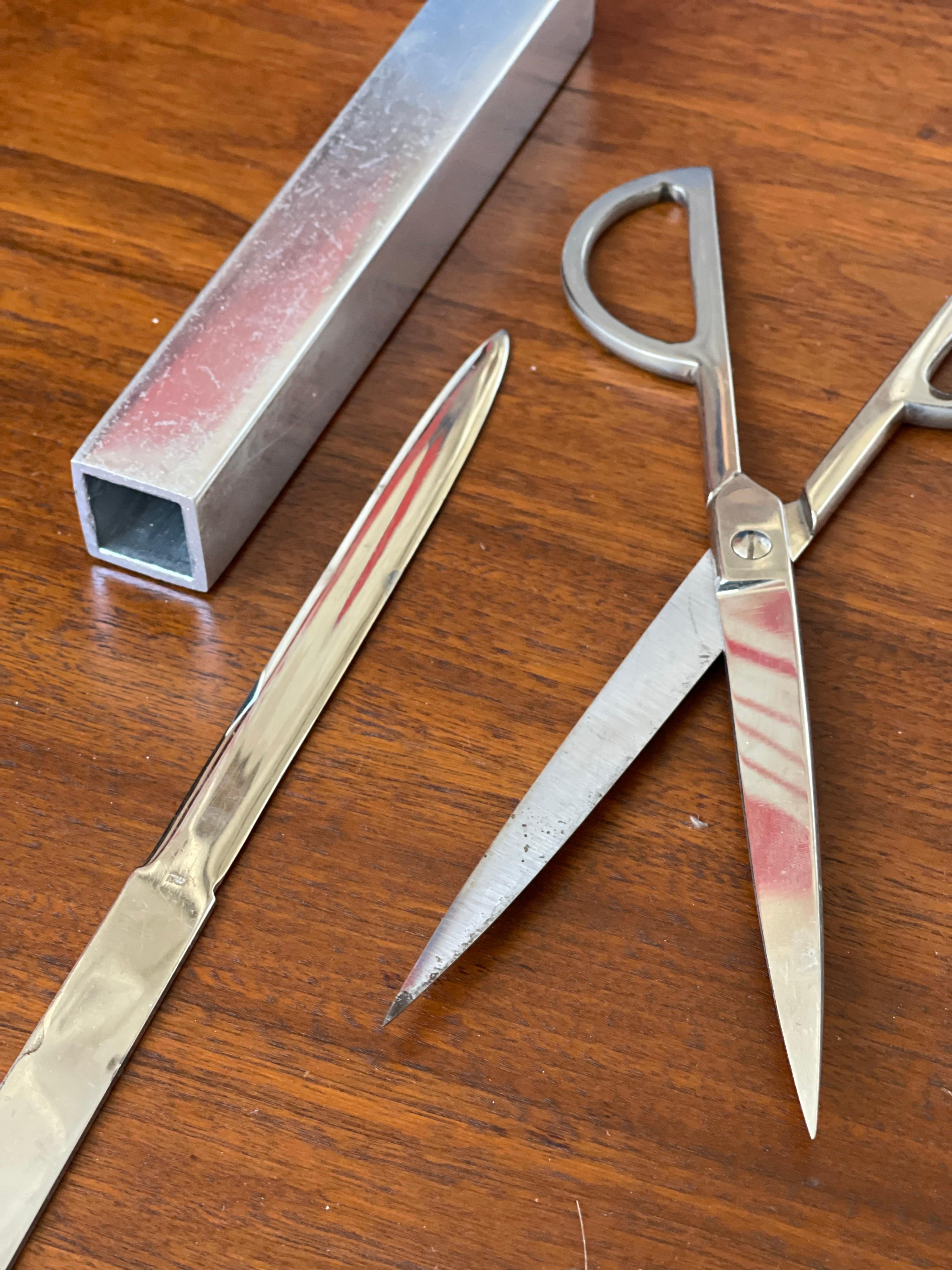 Sleek desk set of stainless steel scissors and letter opener - with case; marked ITALY. 1950's
Original owner put the felt pads on. Jens Risom would use these exact pieces in the desk sets he sold. 

Please notice the minor abrasions wear - these