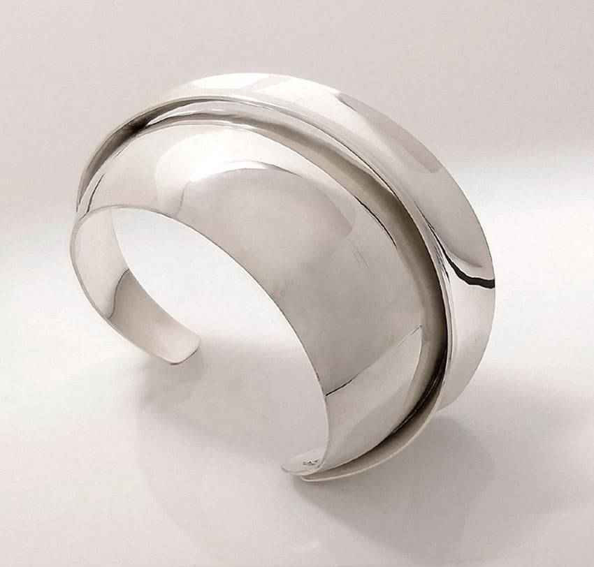 This 1980’s Gerhard Herbst studio Bangle is hand constructed from two individual shell form components and fits wrist sizes from 6 1/2’’ to 6 7/8’’. 

Estimated total production: 72 pieces.
Marks: sterling/ Artist signature 

Modernist designer,