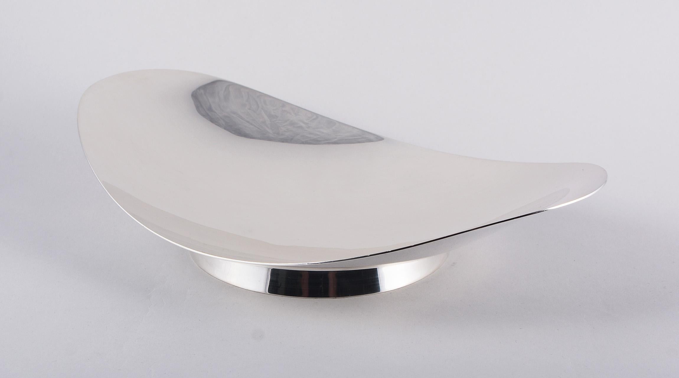 Modernist center bowl in sterling silver by Tiffany. This has a shallow oval form on circular foot. The bowl is marked Tiffany & Co. Makers sterling silver 22416. This bowl dates to the 1940s to the mid-1950s. The bowl weighs approximately 730