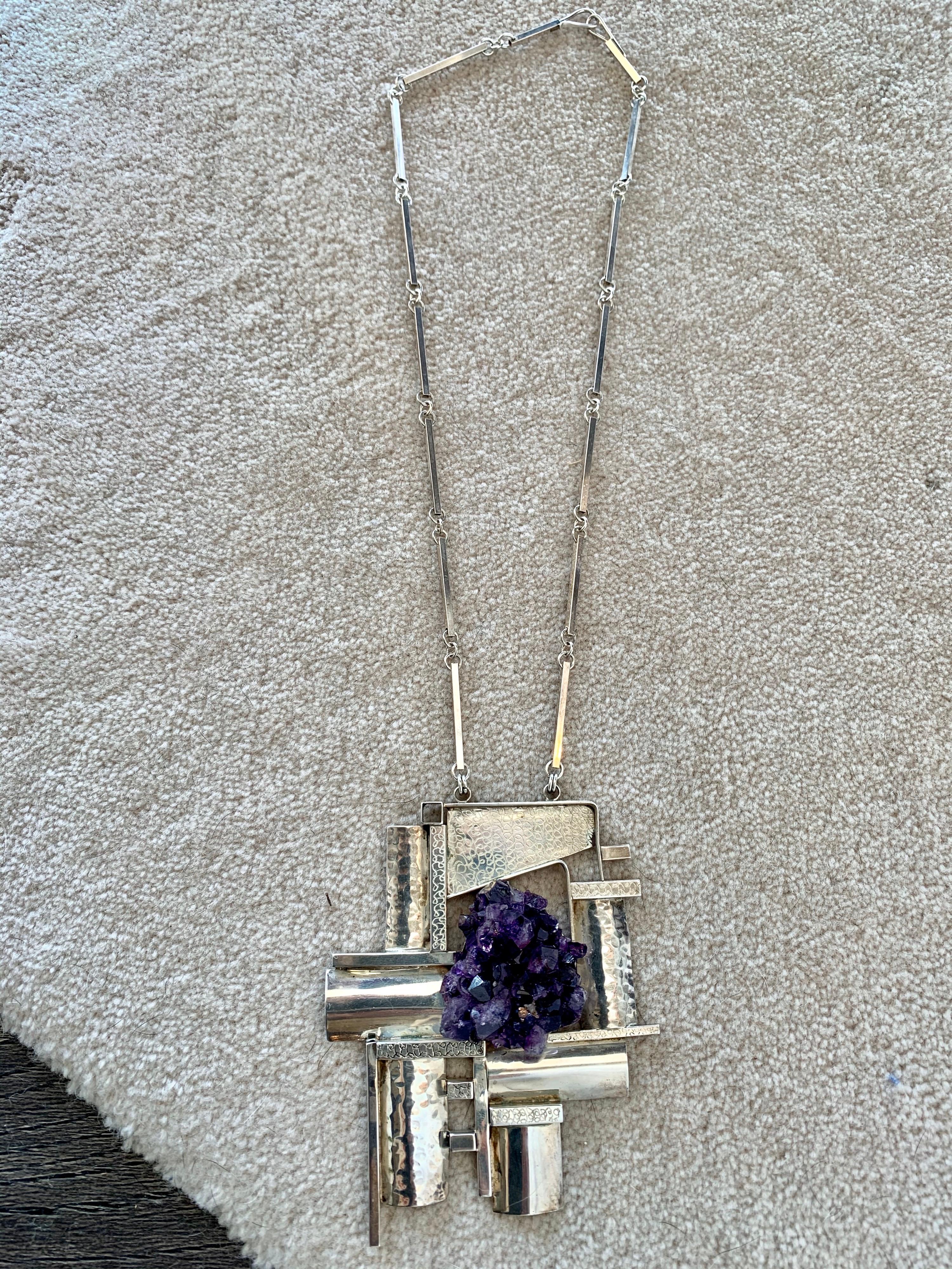 Artisan crafted sterling silver necklace in a modernist/ cubist design with raw amethyst crystal geode, marked sterling and signed by artist to backside of pendant (difficult to determine the signature). One of a kind cubic Brutalist design,