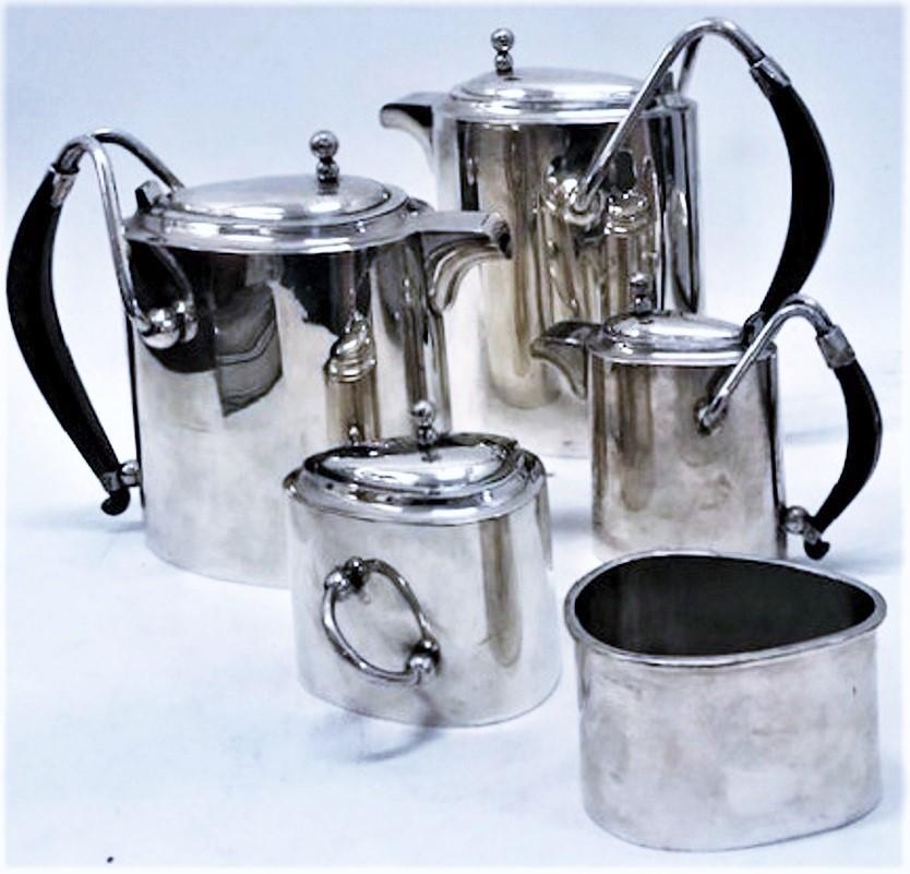 ABOUT
This elegant Modernist large six-piece sterling silver service for coffee and tea is of a superb workmanship and consists of a tray, a coffee pot, a tea pot, a hot milk or chocolate pot, a sugar bowl and a milk jar. The entire set, designed