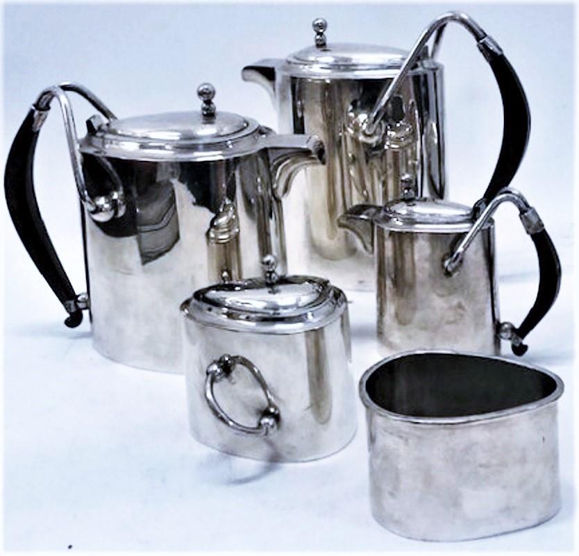 CIRCA
Questo elegante servizio modernista di sei pezzi in argento sterling per il caffè e il tè è di superba fattura e consiste in un vassoio, una caffettiera, un bricco per il tè, un bricco per il latte caldo o la cioccolata, una zuccheriera e un