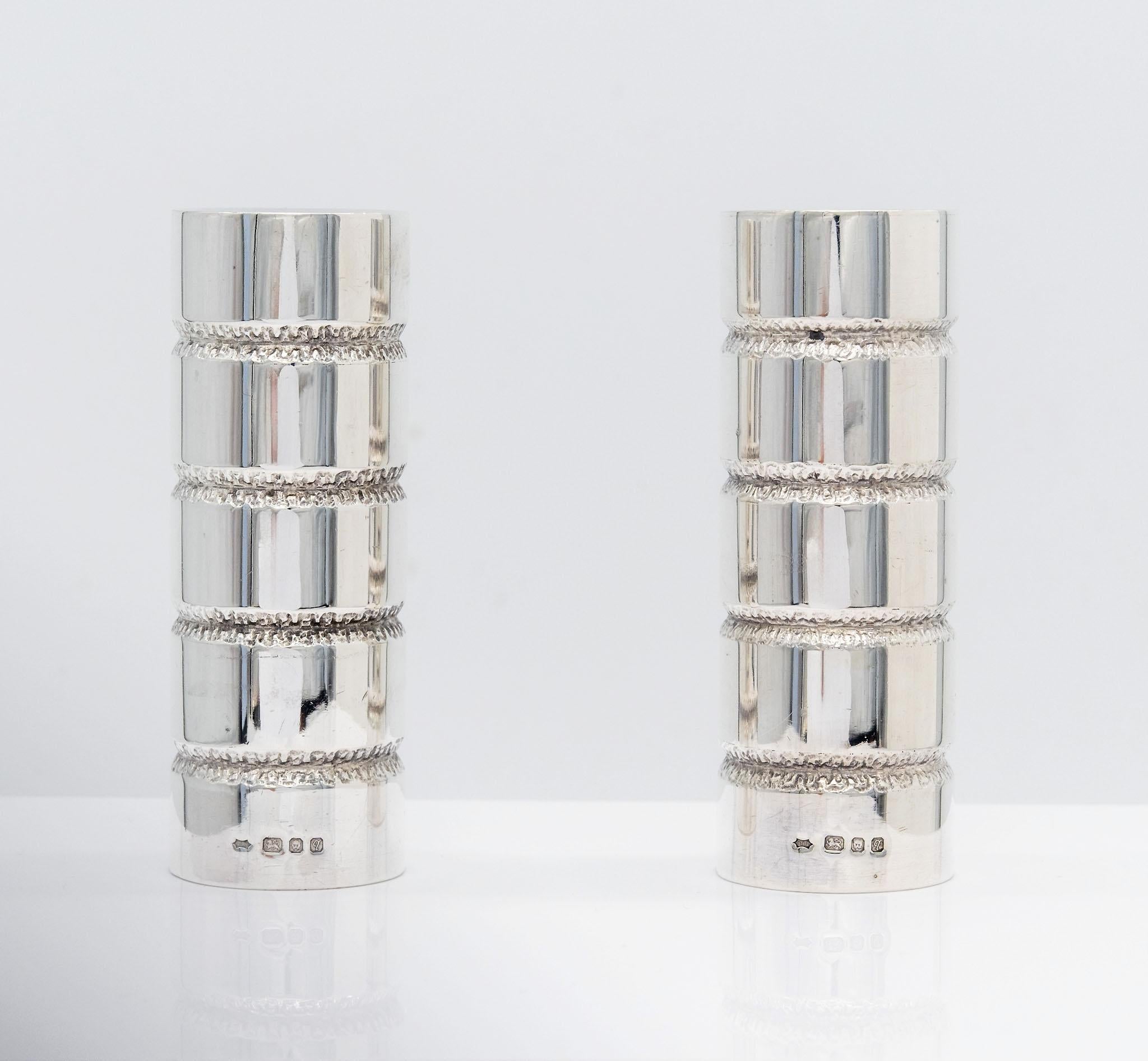 Ein modernistisches Salz- und Pfefferstreuer-Set aus Sterlingsilber von George Edward Grant - London 1971. Vollständig gepunzt.

Diese prächtigen Töpfe haben eine zylindrische Form mit strukturiertem, gebändertem Dekor. Sie fühlen sich gut an. Die