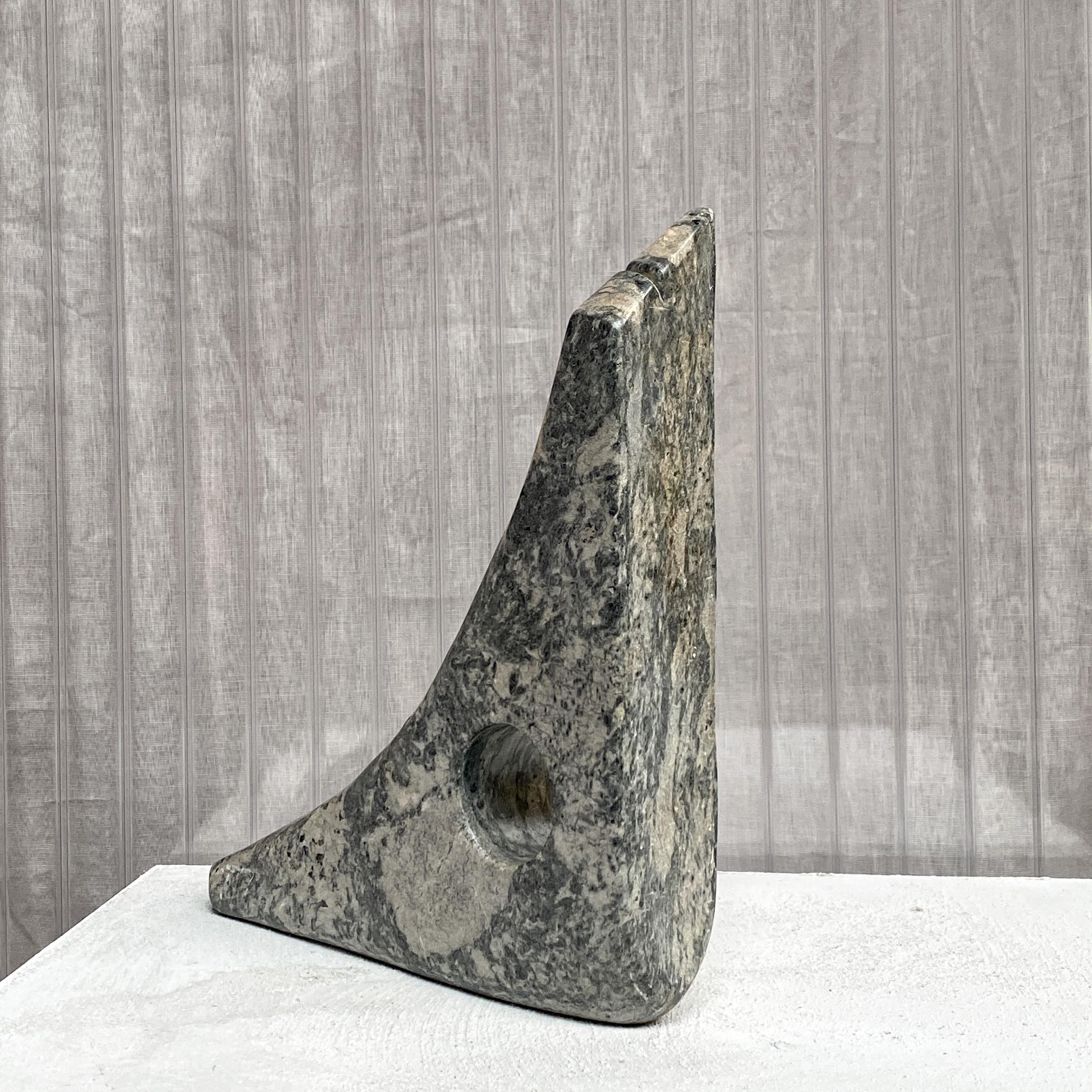 An intruding abstract sculpture in a triangular shape with a circular hole. A playful interpretation of an open & closed volume, reminiscent of the works Isamu Noguchi. Although not big in size, the sculpture as a strong spatial presence. Handcarved