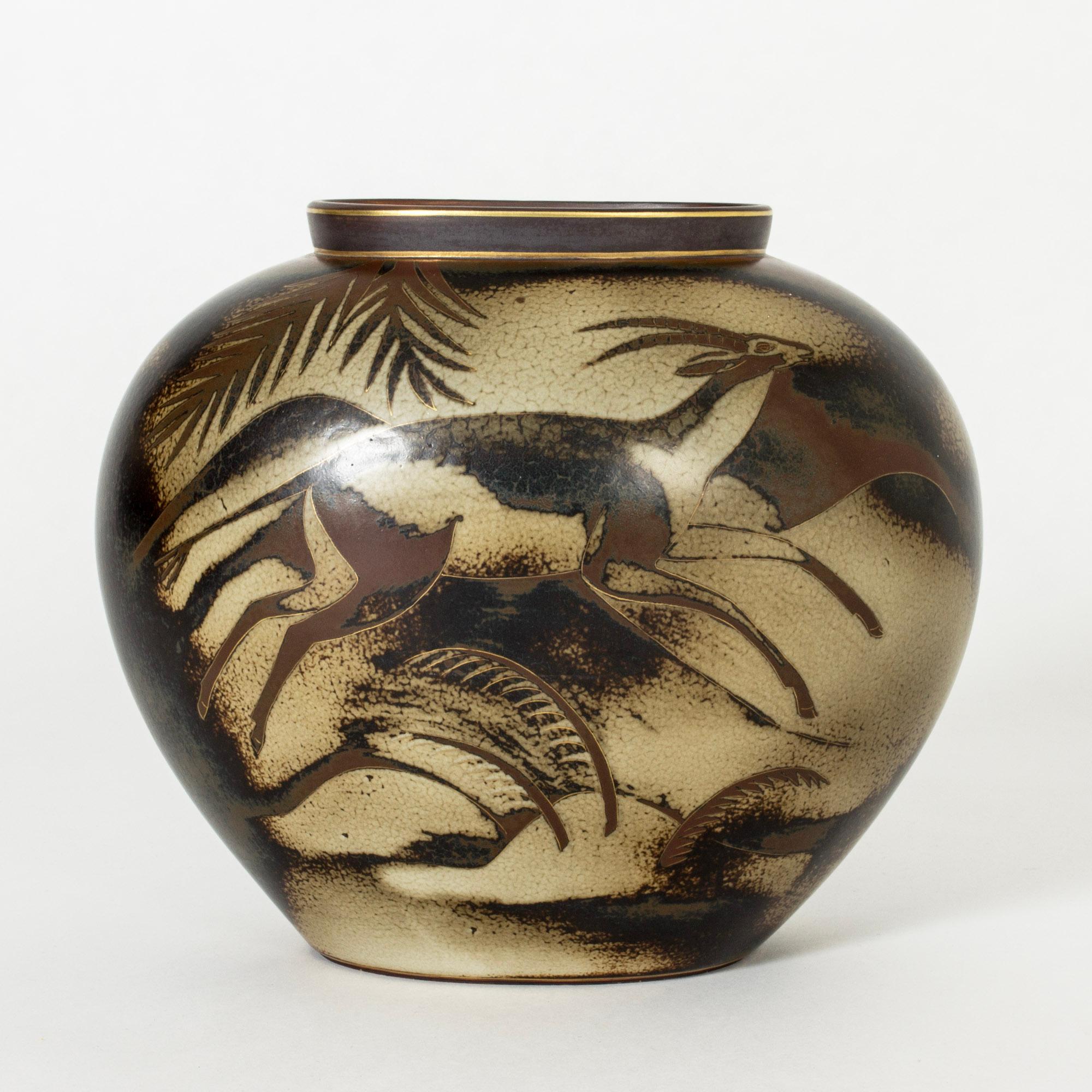 Striking stoneware vase by Gunnar Nylund, from the “Flambé” series. Dramatic decor of a lion hunting antelope on the savannah. Gold decor accentuate the lines.

Gunnar Nylund was one of the most influential ceramicists and designers of the Swedish