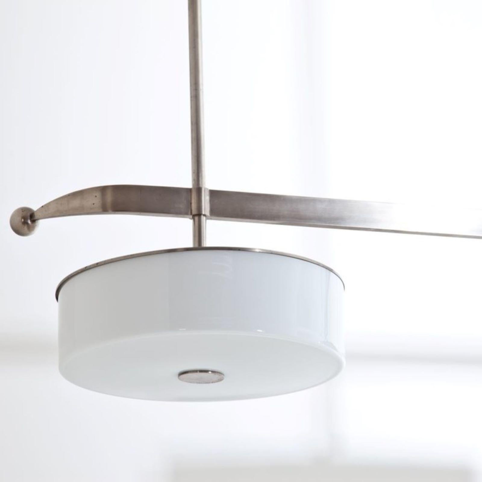 Lámpara de techo modernista de latón niquelado. Luminaria de tres luces con difusores de cristal y 
Increíble pátina.
Seis enchufes en total.
  