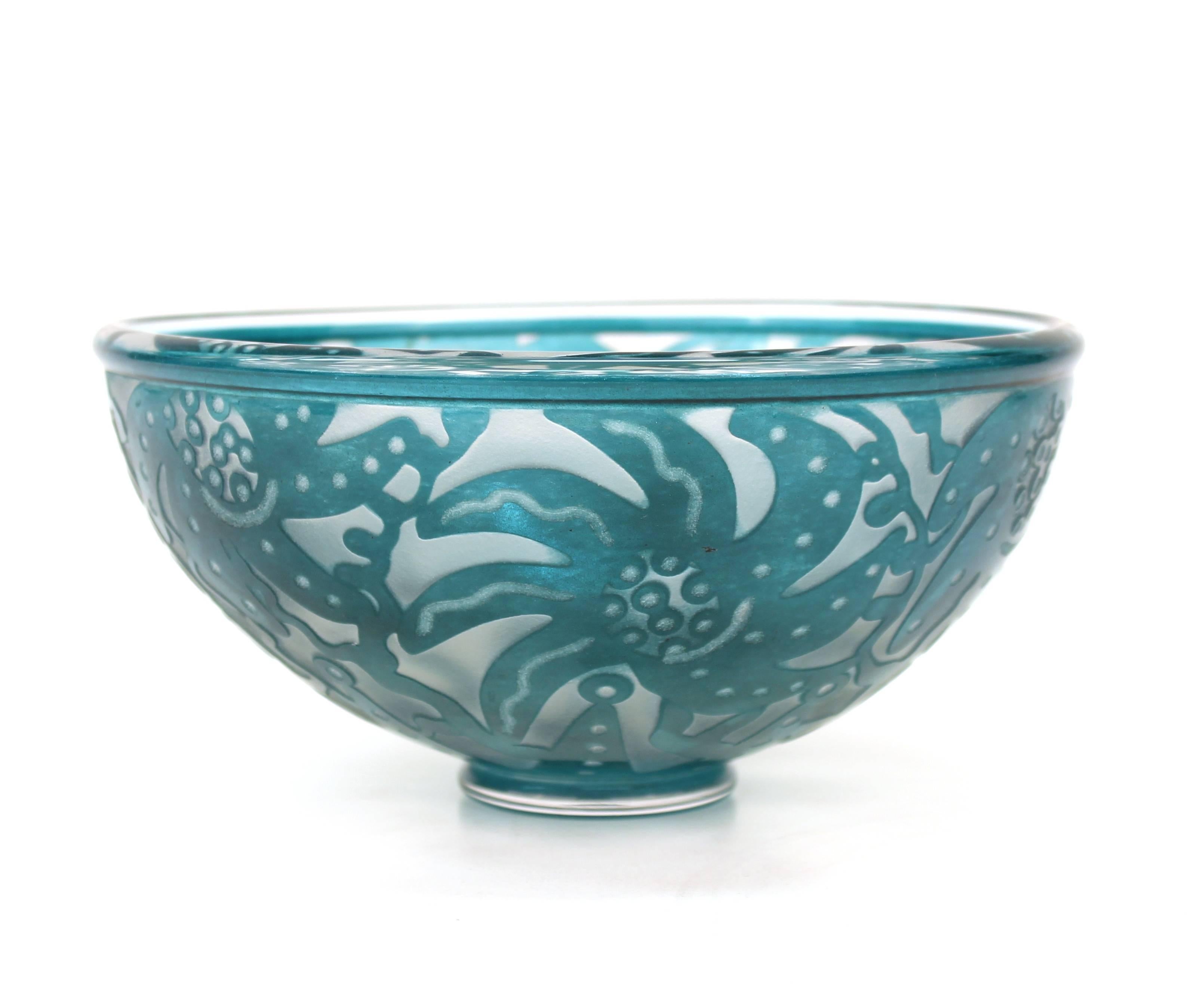 Modernist studio art glass bowl in blue. Designed with pattern of stylized flowers and leaves. Illegibly signed on base. Wear appropriate to age and use. The bowl remains in good vintage condition. 