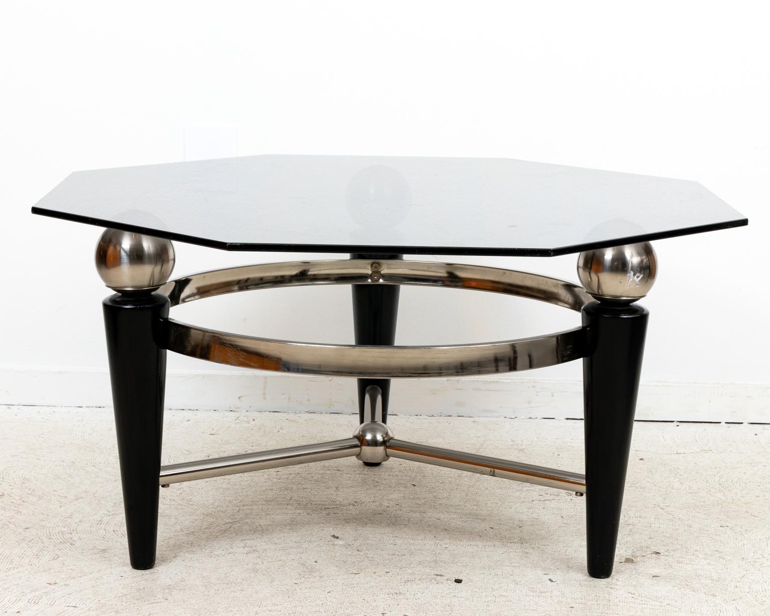 Circa mid-20th century Modernist style coffee table with Ebony and Steel base. The table features a Hexagonal smoke glass top on three steel orbs supported by tapered ebony legs with Steel ring and cross stretcher supports. Very good vintage
