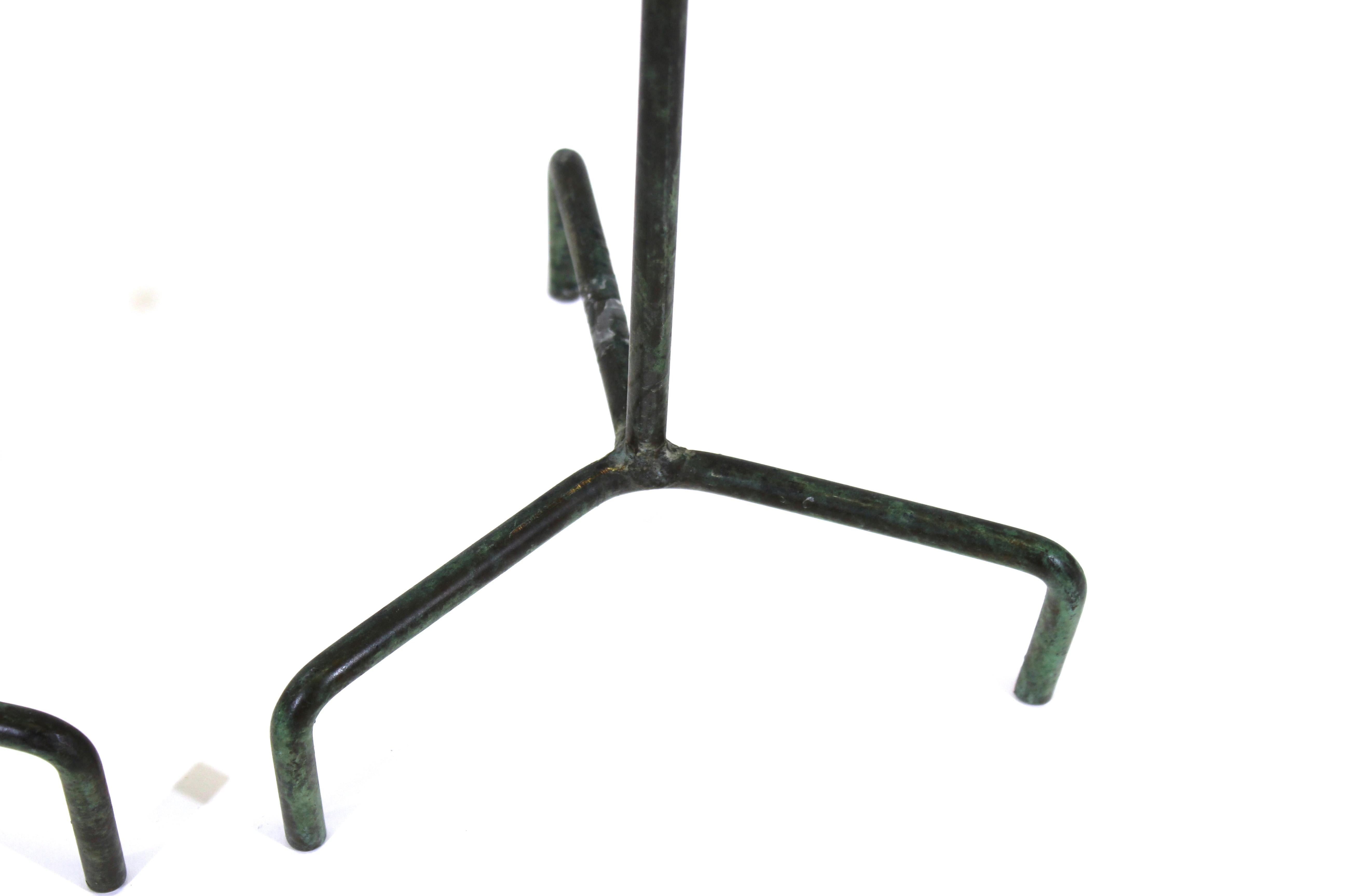 Pair of modernist style metal tripod candlesticks with verdigris finish, with makers marks on the bottom of the candle plates.