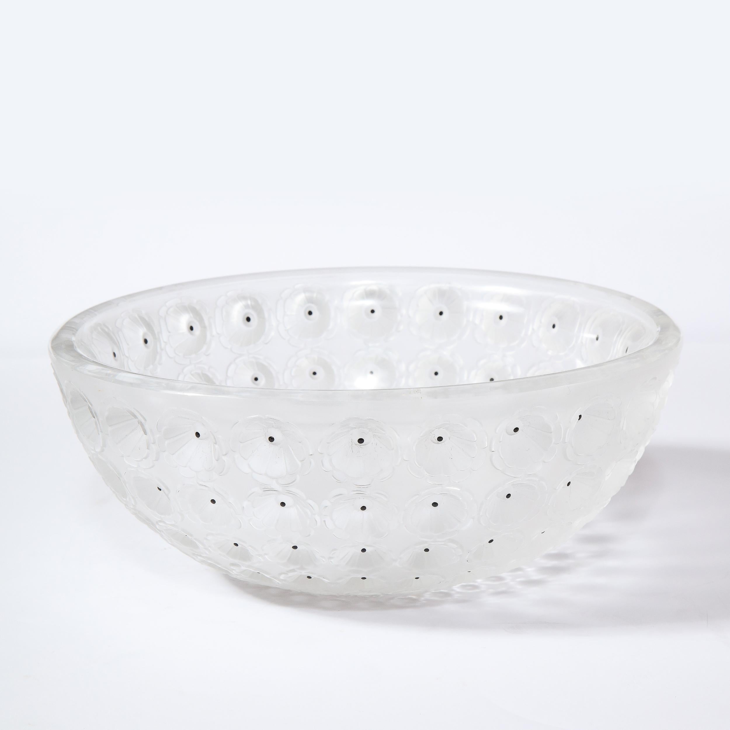 This stunning modernist bowl was realize in France, in the manner of Lalique. It features a conical form with a wealth of depressions with black dot detailing in glass at the center of circular depressions with stylized floral detailing etched into