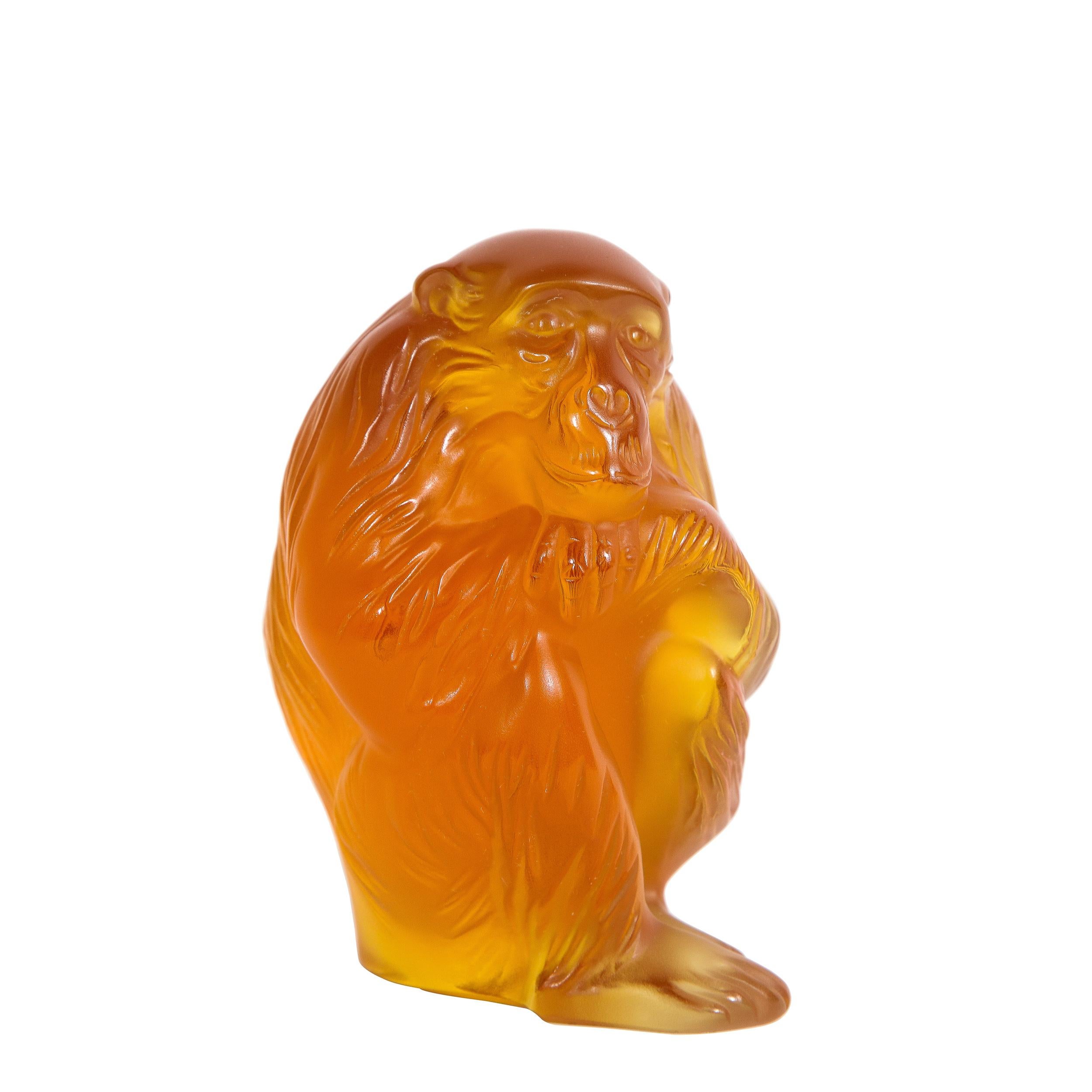 This elegant modernist decorative object was realized in France by the celebrated maker Lalique. It features figurative stylized crouching monkey figurine in carnelian glass. With its beautiful craftsmanship by one of France's great luxury glass
