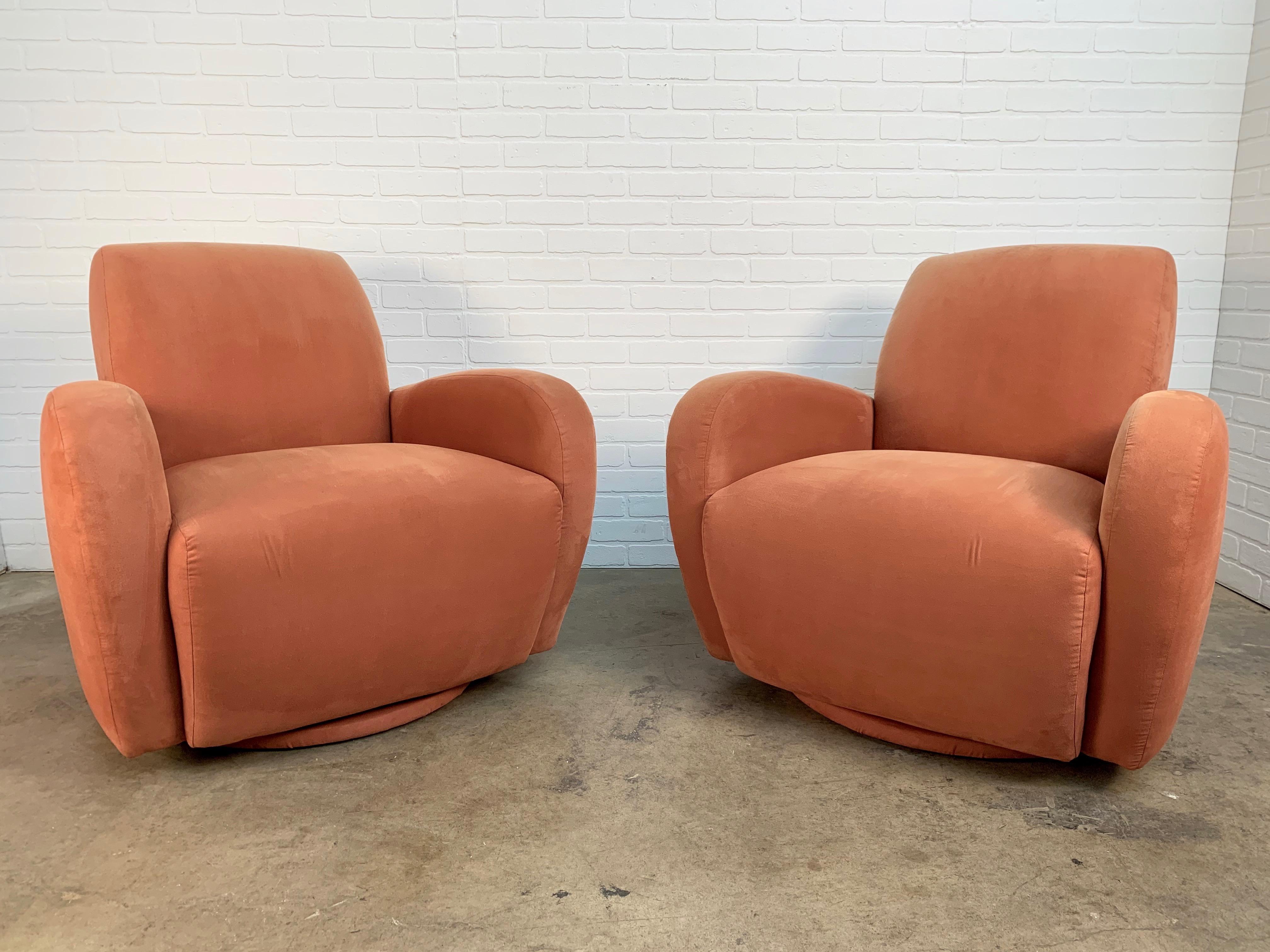 A pair of 1980s Art Deco lounge chairs in coral microfiber. In the style of Kagan or Donghia These chairs need new upholstery. Very faded on one side.