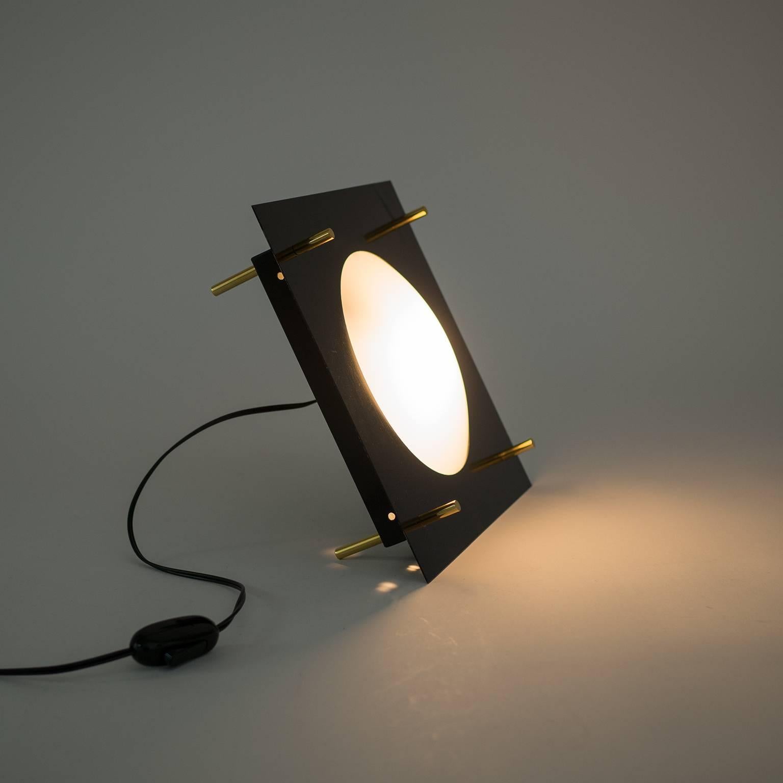 A very remarkable modernist architectural Stilnovo table lamp or light object. Its bold sculptural design is reminiscent of early pieces by Angelo Lelli and Ettore Sottsass. Two lacquered steel parts are held together by minimalist brass elements.