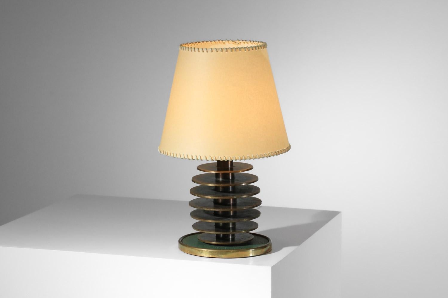 French table lamp from the 40s and 50s. Lamp base made of solid brass disks in the style of Maison Desny's work of the period. Lamp base covered with green Skaï. Presentation shade on request. Beautiful vintage condition, with a beautiful patina of
